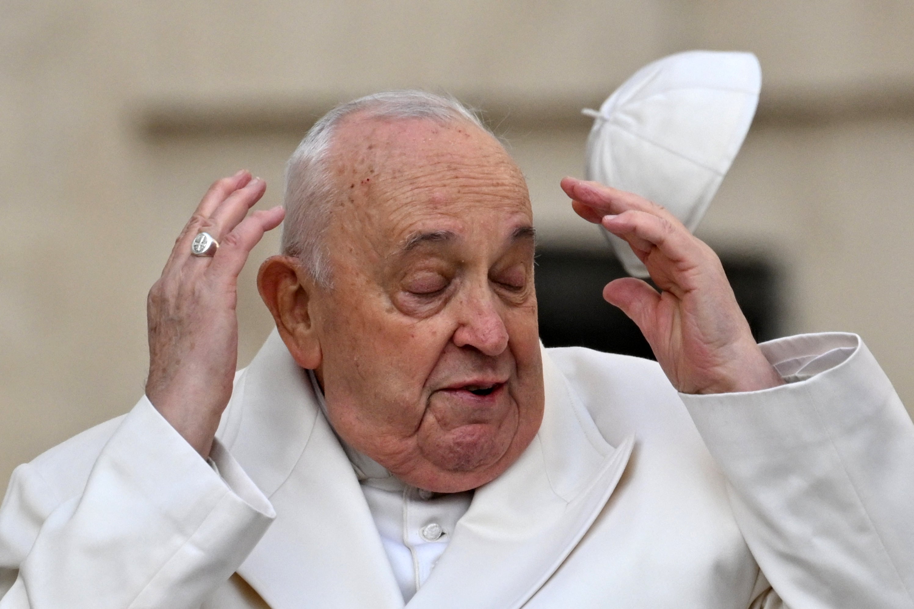 Wind blows Pope Francis’ cap off his head as he arrives for his general audience in St. Peter Square at the Vatican on Monday