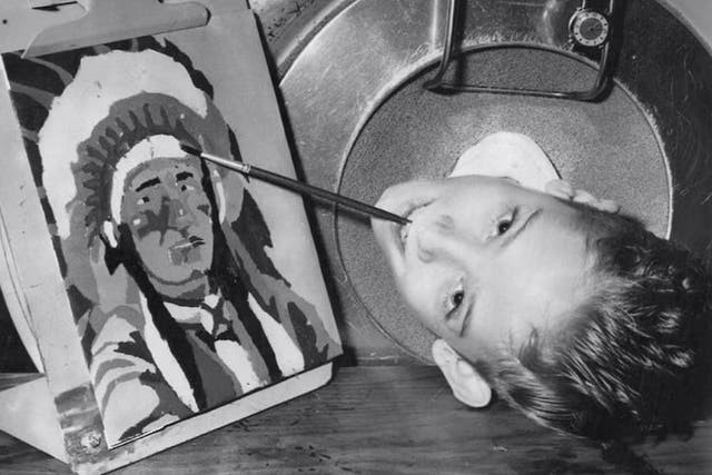 <p>Paul Alexander pictured as a young boy, as he learned to paint with his mouth </p>
