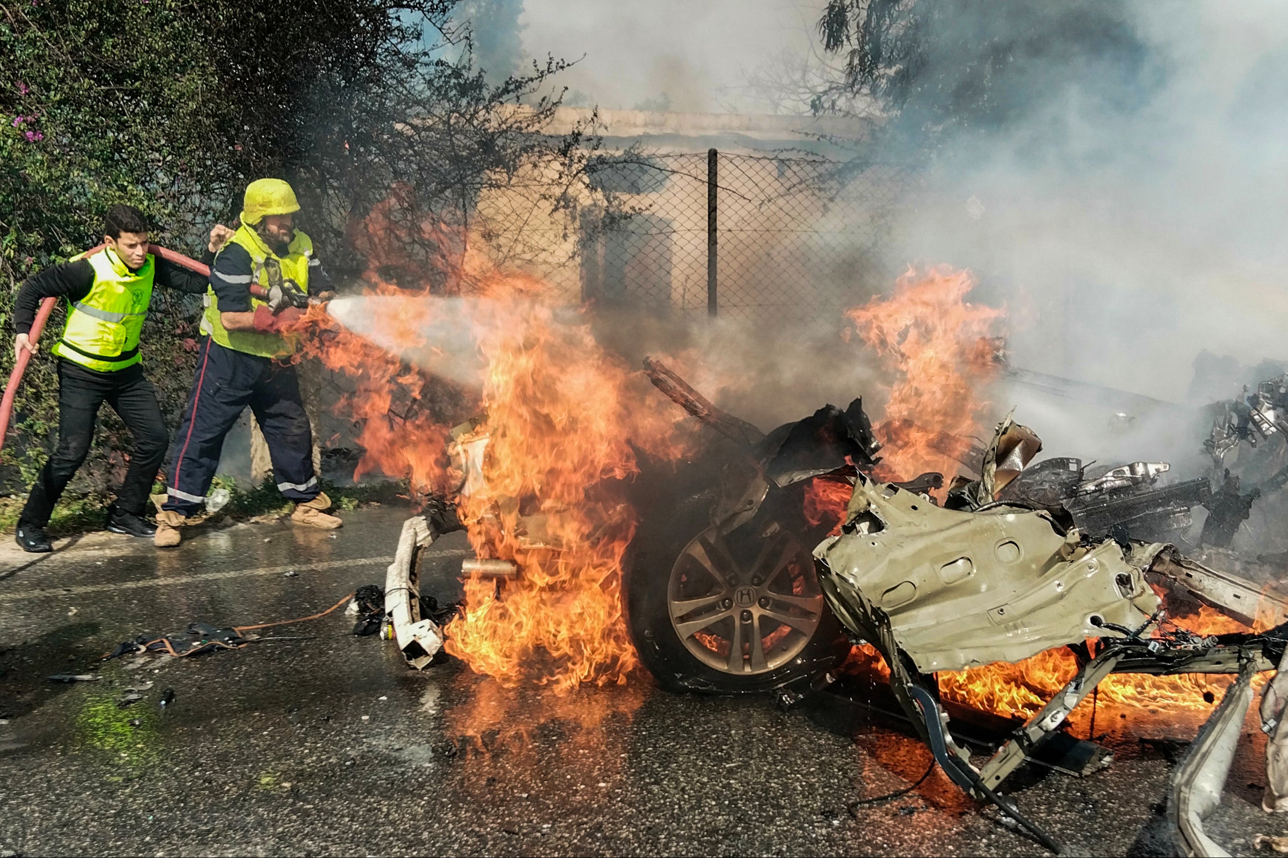 Firefighters douse a burning car after it was hit in an Israeli strike in Lebanon’s southern area of Tyre on Wednesday