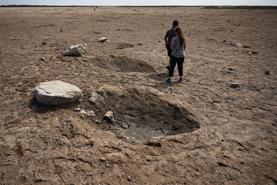 Members of the public walk through a debris field at the launch pad on 22 April, 2023, after the SpaceX Starship lifted off on 20 April for a flight test from Starbase in Boca Chica, Texas