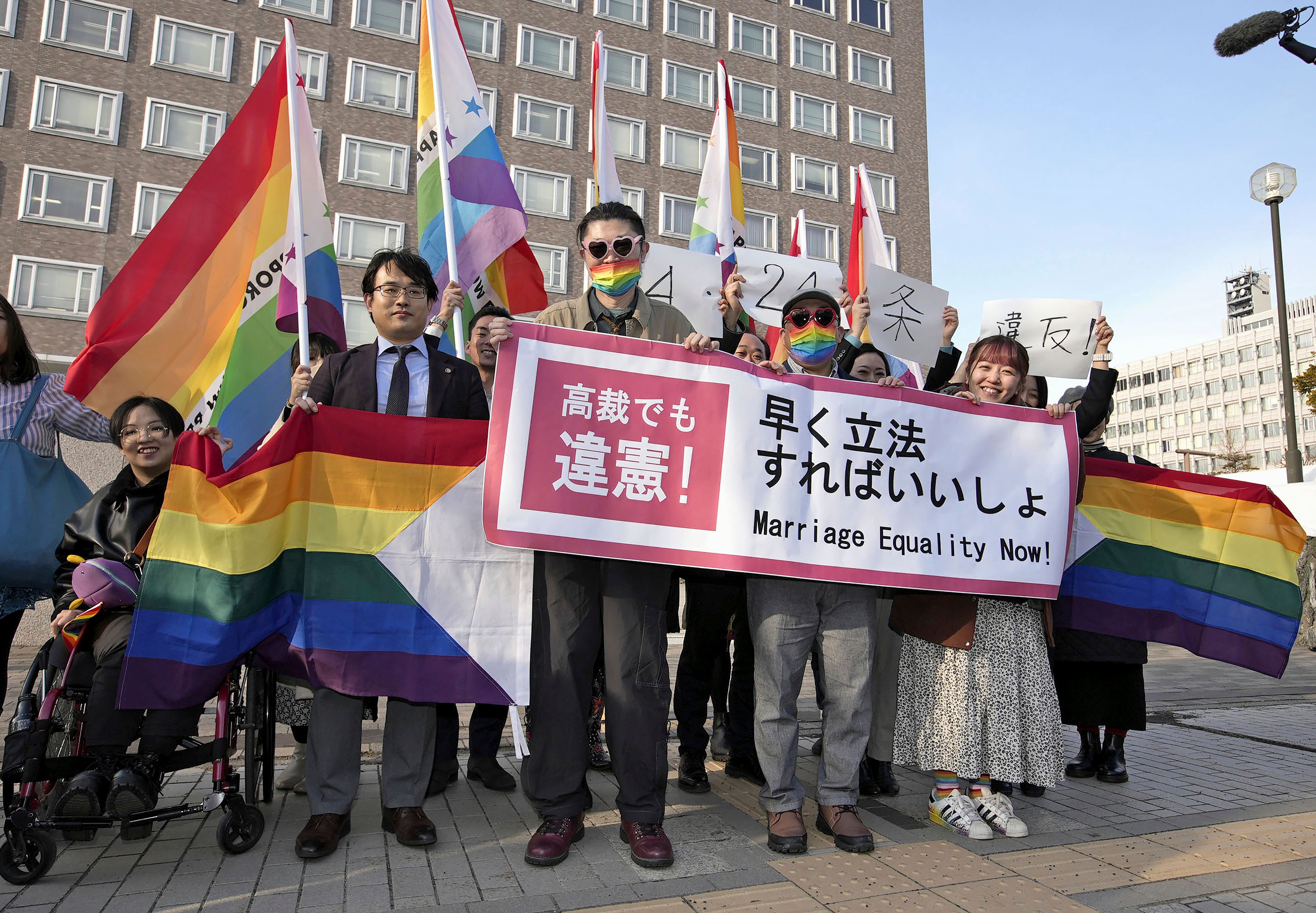 Plaintiffs and others shows a banner in front of Sapporo Hight Court in Sapporo, Hokkaido, northern Japan Thursday