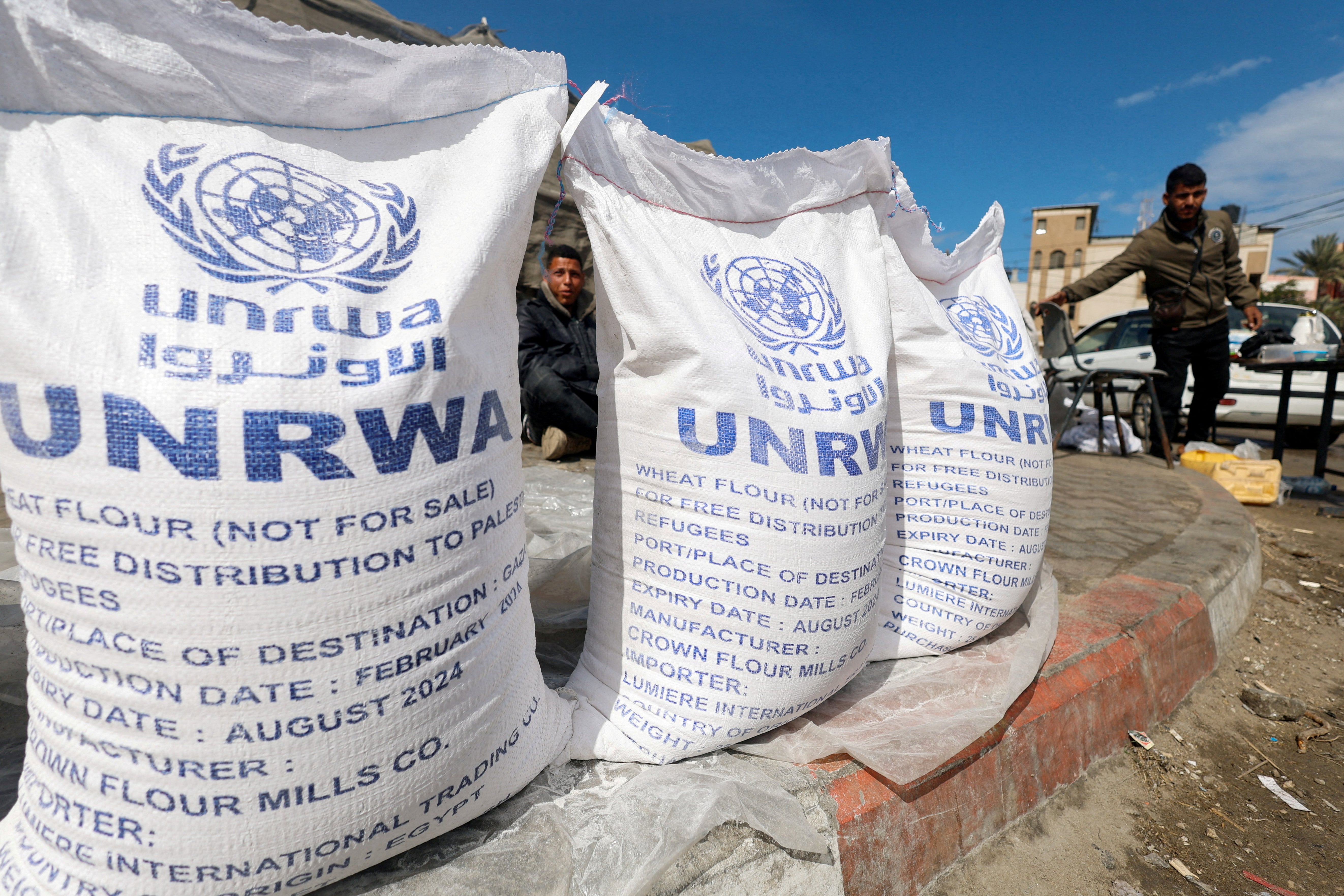Displaced Palestinians wait to receive UNRWA aid in Rafah