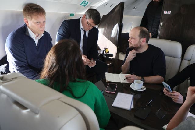 <p>Grant Shapps, left, on the plane from Poland</p>