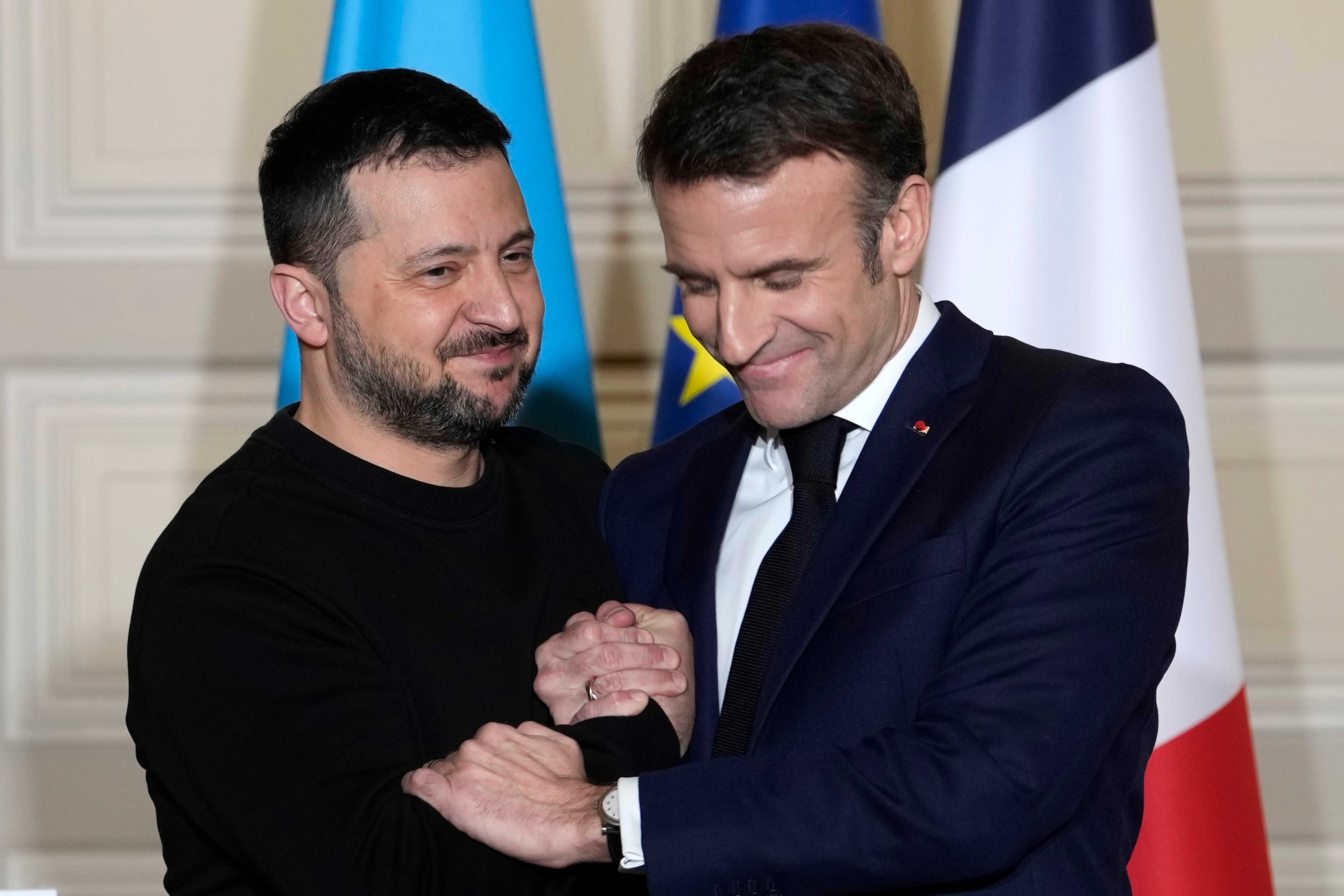 Ukrainian President Volodymyr Zelenskyy, left, and French President Emmanuel Macron shake hands after a press conference in February
