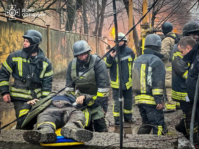<p>Rescuers carry an injured colleague at the site of a Russian missile strike in Odessa on Friday  </p>