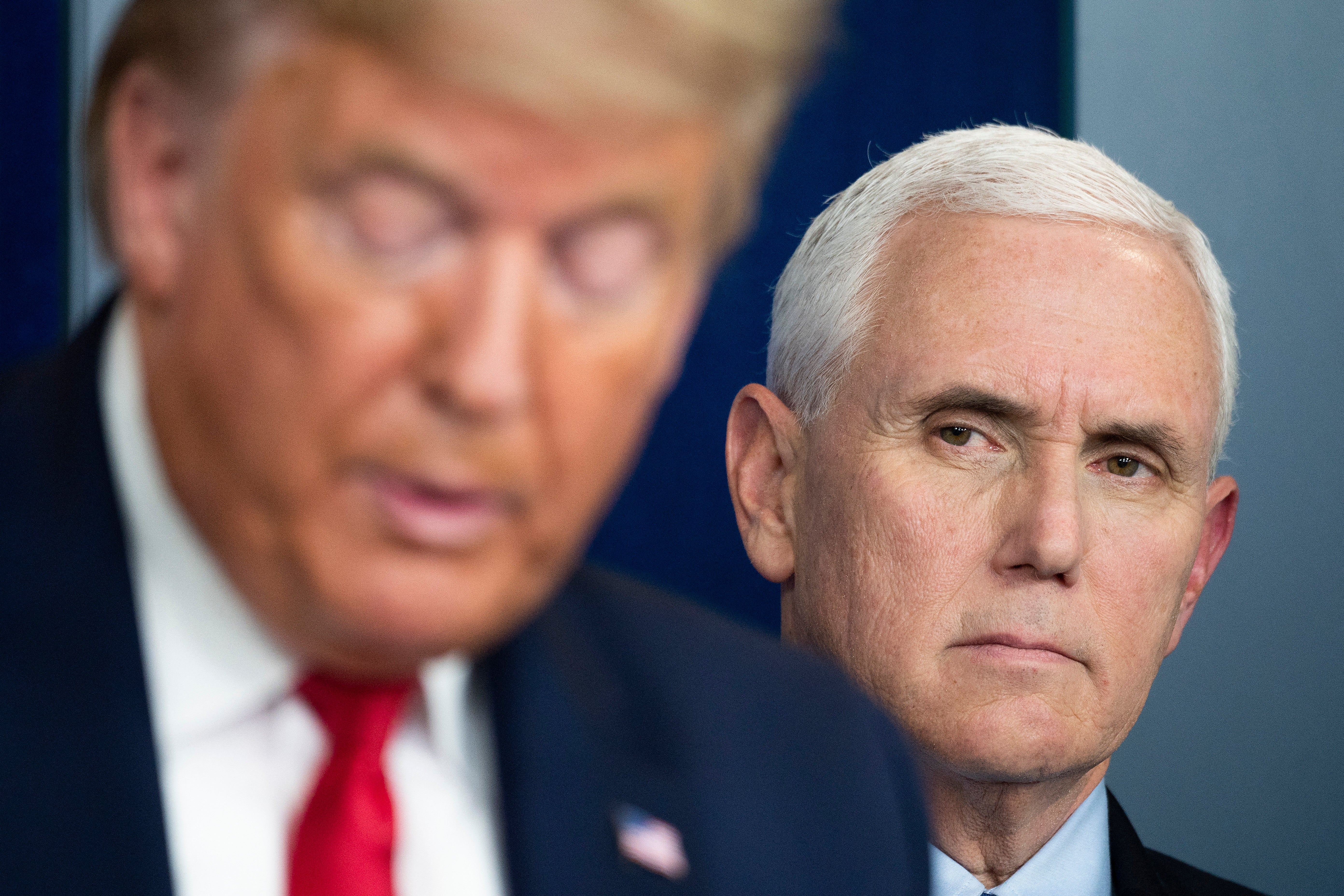 Then-vice president Mike Pence listens as then-president Donald Trump speaks during White House press conference in March 2020