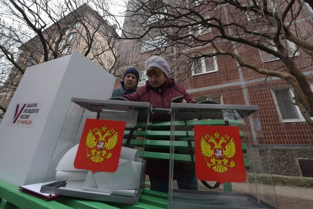 <p>People cast their votes at a mobile polling station during early voting in Russia's presidential election in Russian-controlled part of Donetsk region, Ukraine</p>