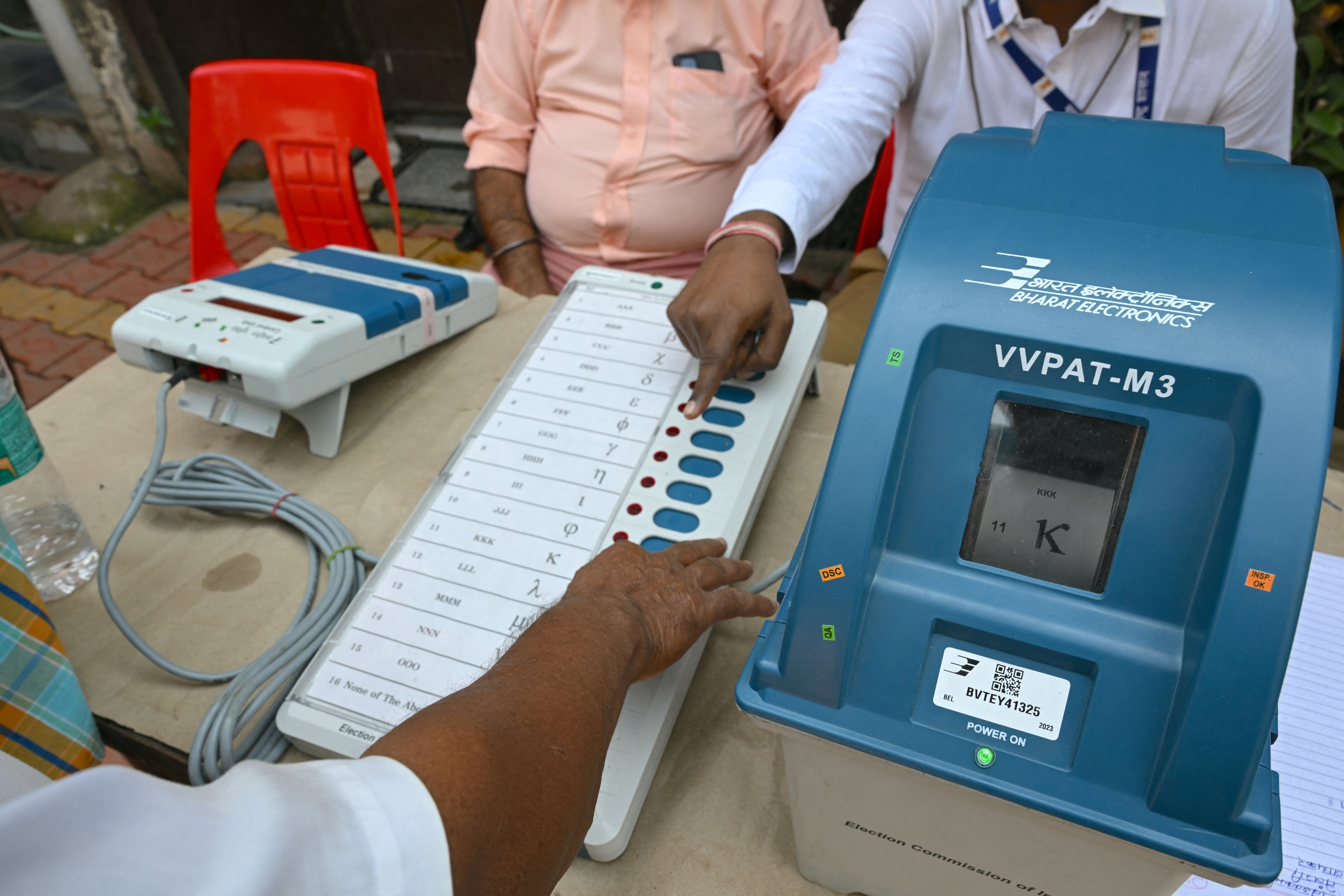 Indian election official (R) demonstrates the use of the Voter Verifiable Paper Audit Trail