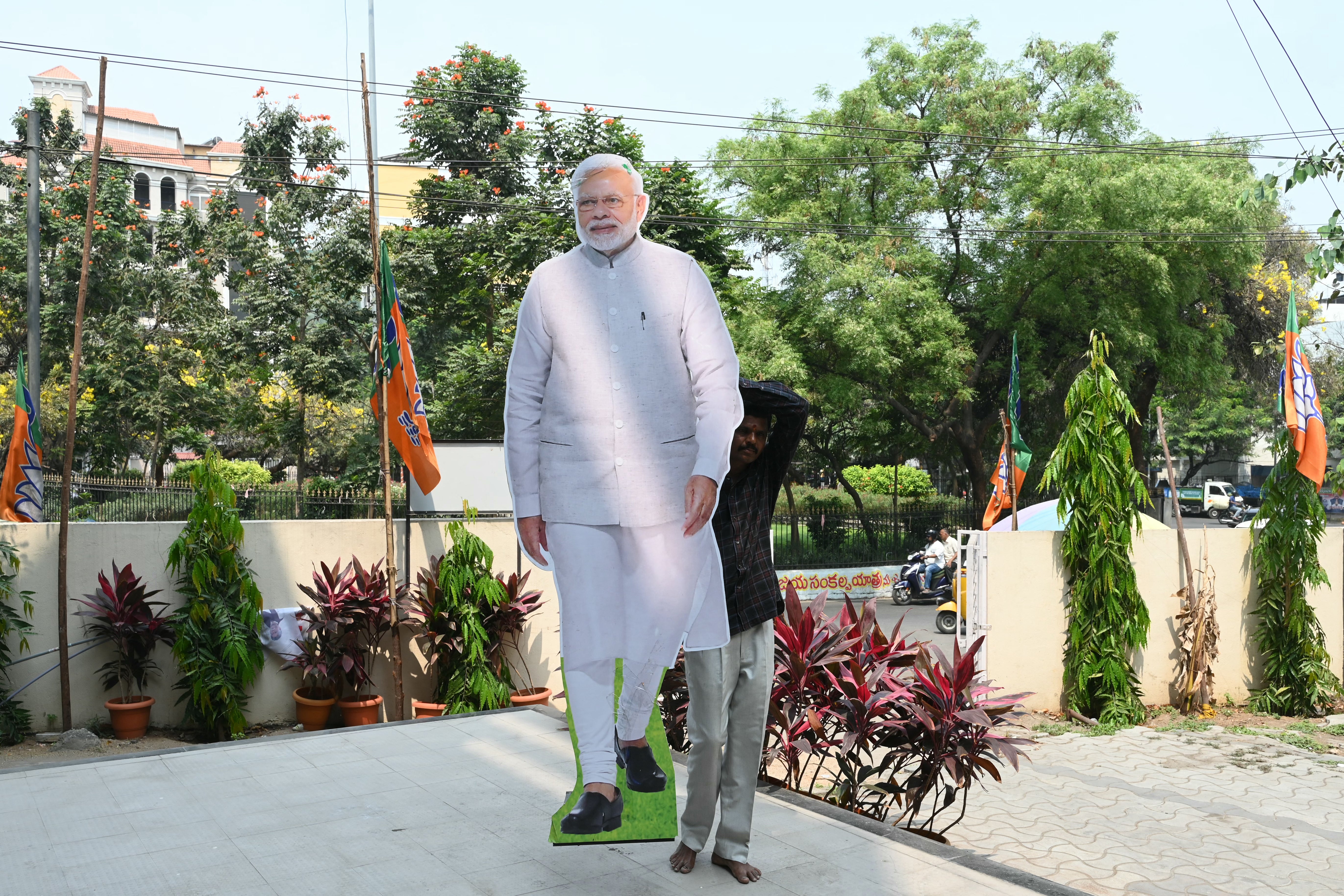 A worker carries a cutout of India's Prime Minister Narendra Modi outside a Bharatiya Janata Party (BJP) office