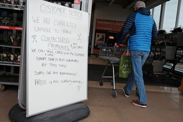 A handwritten sign outside a Sainsbury’s store in Cobham informing customers of technical issues affecting the supermarket chain (Yui Mok/PA)