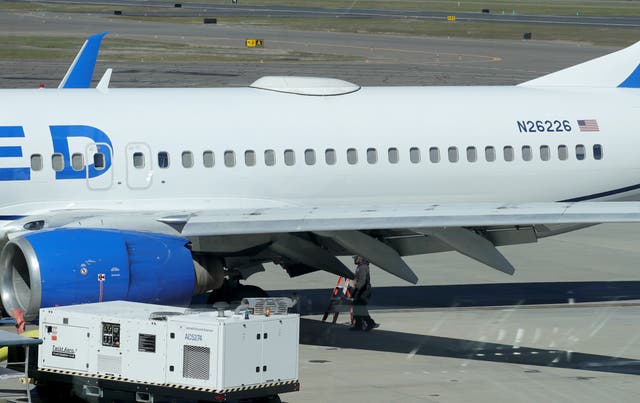 <p>A Medford Jet Center worker walks under a United Boeing 737-824 that landed at Rogue Valley International-Medford Airport from San Francisco with a missing panel on 15 March 2024</p>