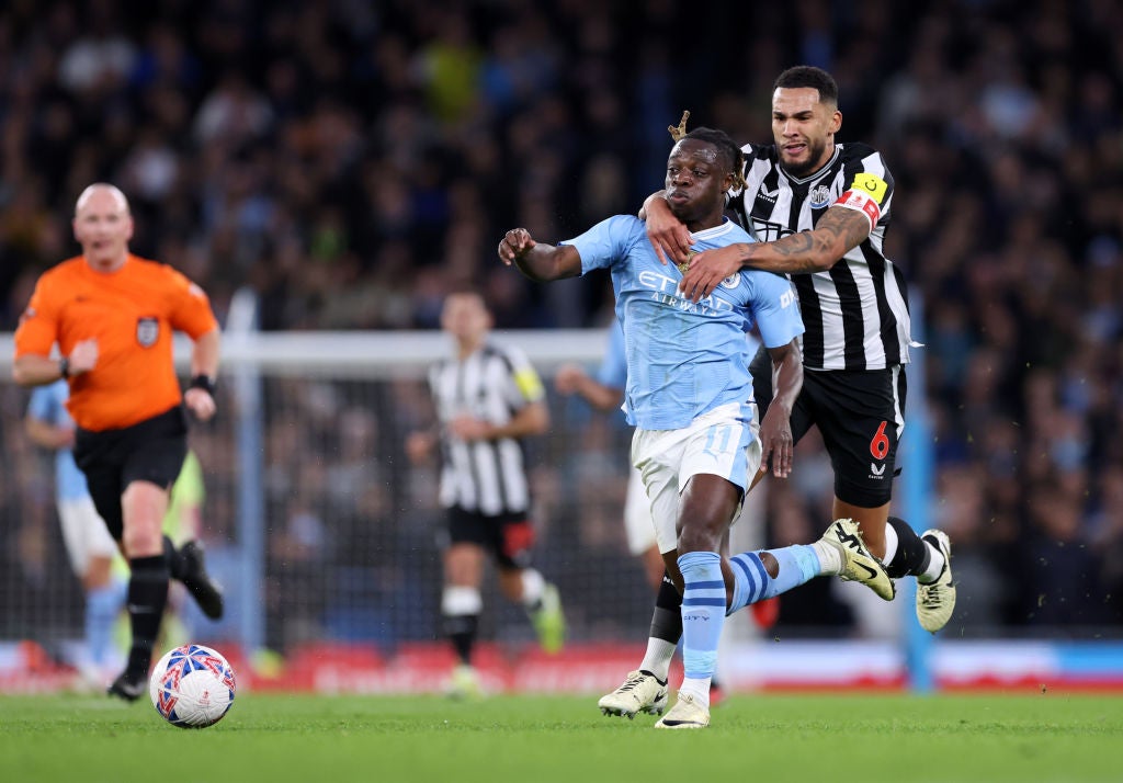 Jeremy Doku of Manchester City is challenged by Jamaal Lascelles