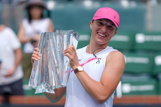Iga Swiatek, of Poland, holds the trophy after defeating Maria Sakkari, of Greece, in the final match at the BNP Paribas Open. (Ryan Sun/AP)