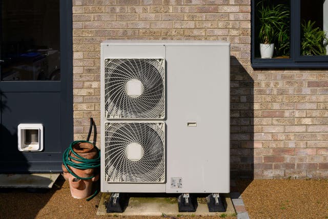 <p>A domestic air source heat pump next to a backdoor</p>