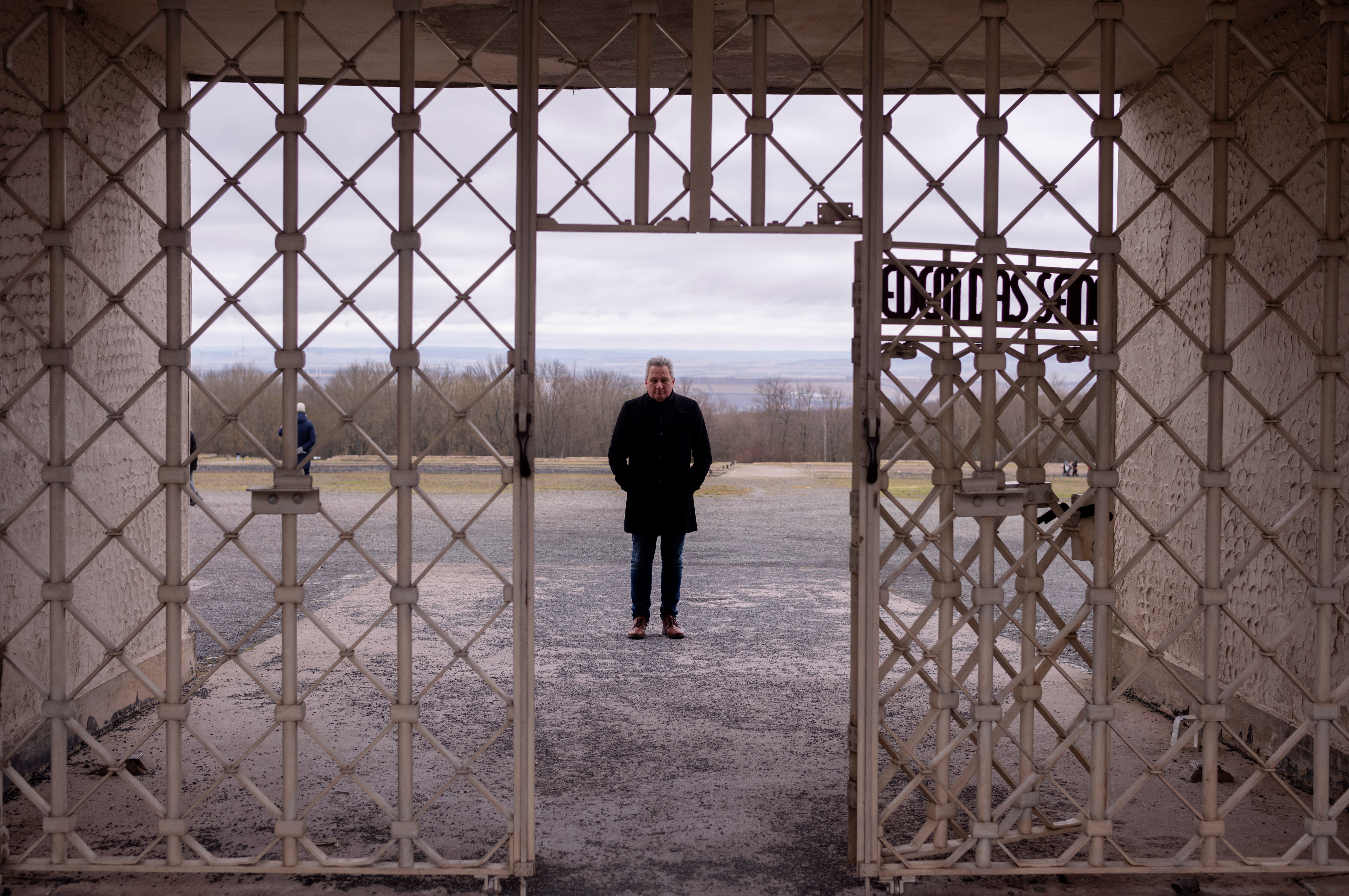 The head of the Buchenwald Memorial, Jens-Christian Wagner, poses for a photo behind the main gate of the former Nazi concentration camp in Weimar, Germany