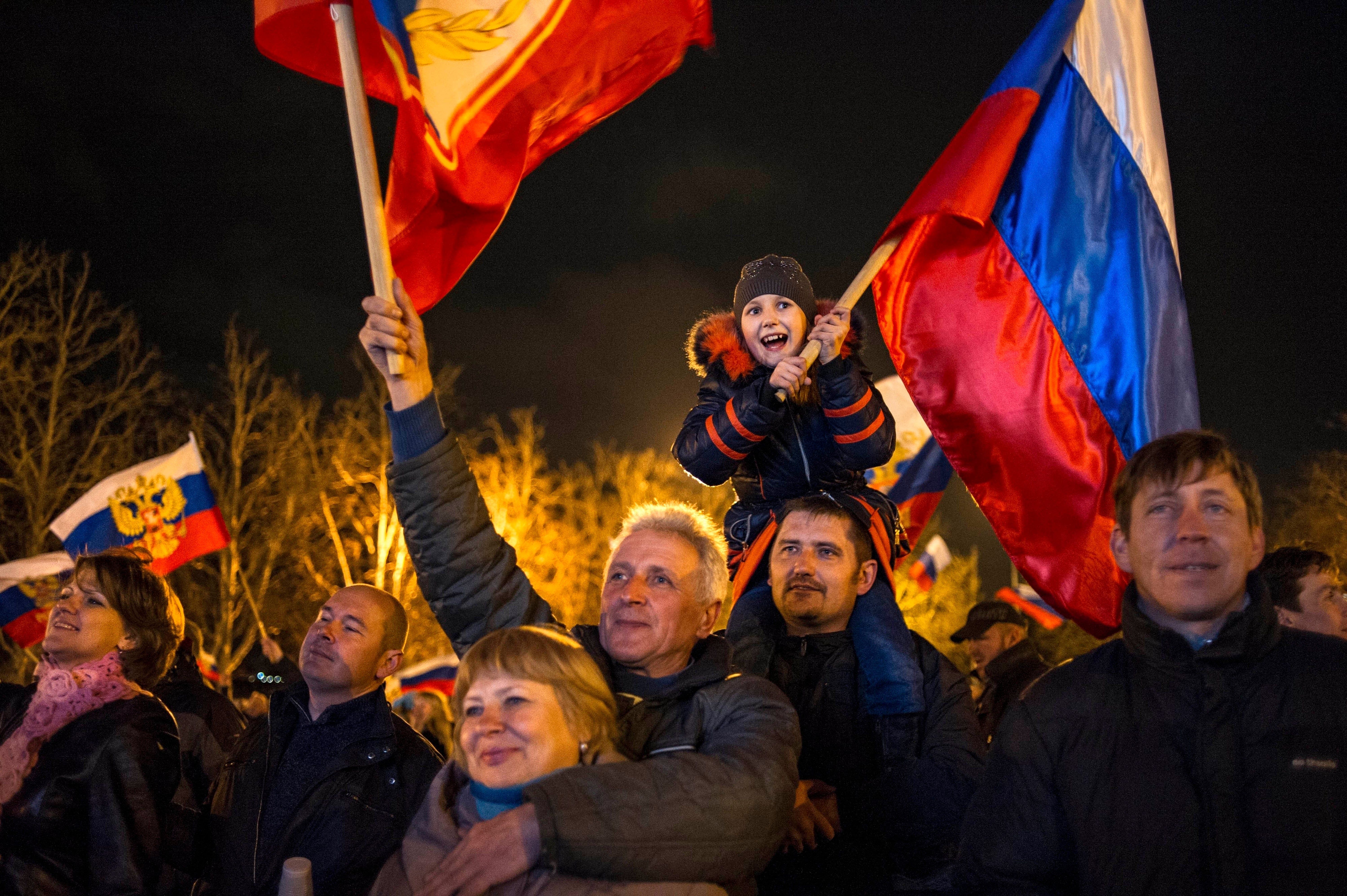 Pro-Russian crowds celebrate in the central square in Sevastopol, Ukraine, on Monday, March 17, 2014. Russian flags fluttered above jubilant crowds after residents of Crimea voted overwhelmingly to secede from Ukraine and join Russia