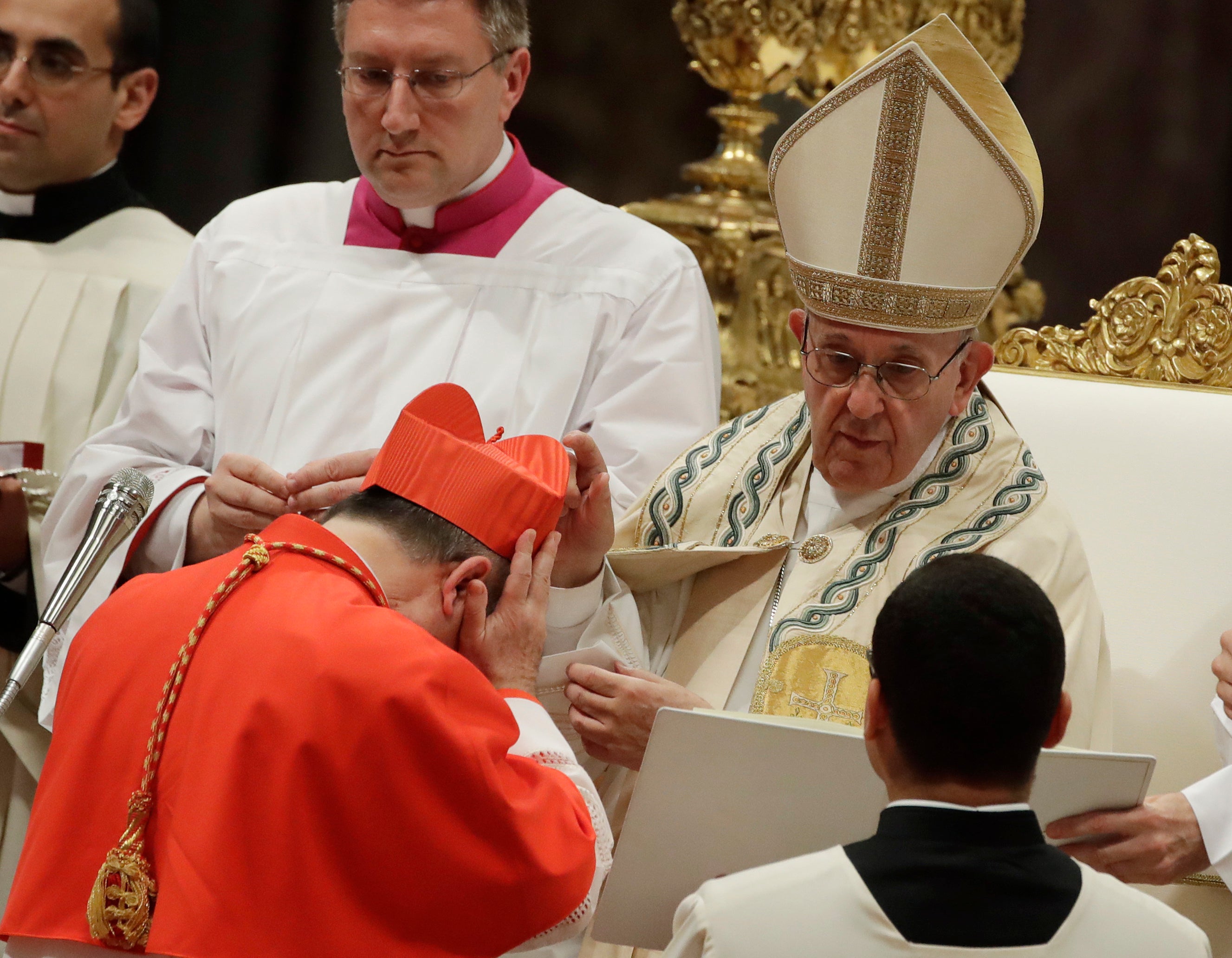 FILE - In this Thursday, June 28, 2018 file photo, Cardinal Giovanni Angelo Becciu receives the red three-cornered biretta hat from Pope Francis during a consistory in St. Peter's Basilica at the Vatican