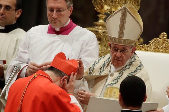 <p>FILE - In this Thursday, June 28, 2018 file photo, Cardinal Giovanni Angelo Becciu receives the red three-cornered biretta hat from Pope Francis during a consistory in St. Peter's Basilica at the Vatican</p>