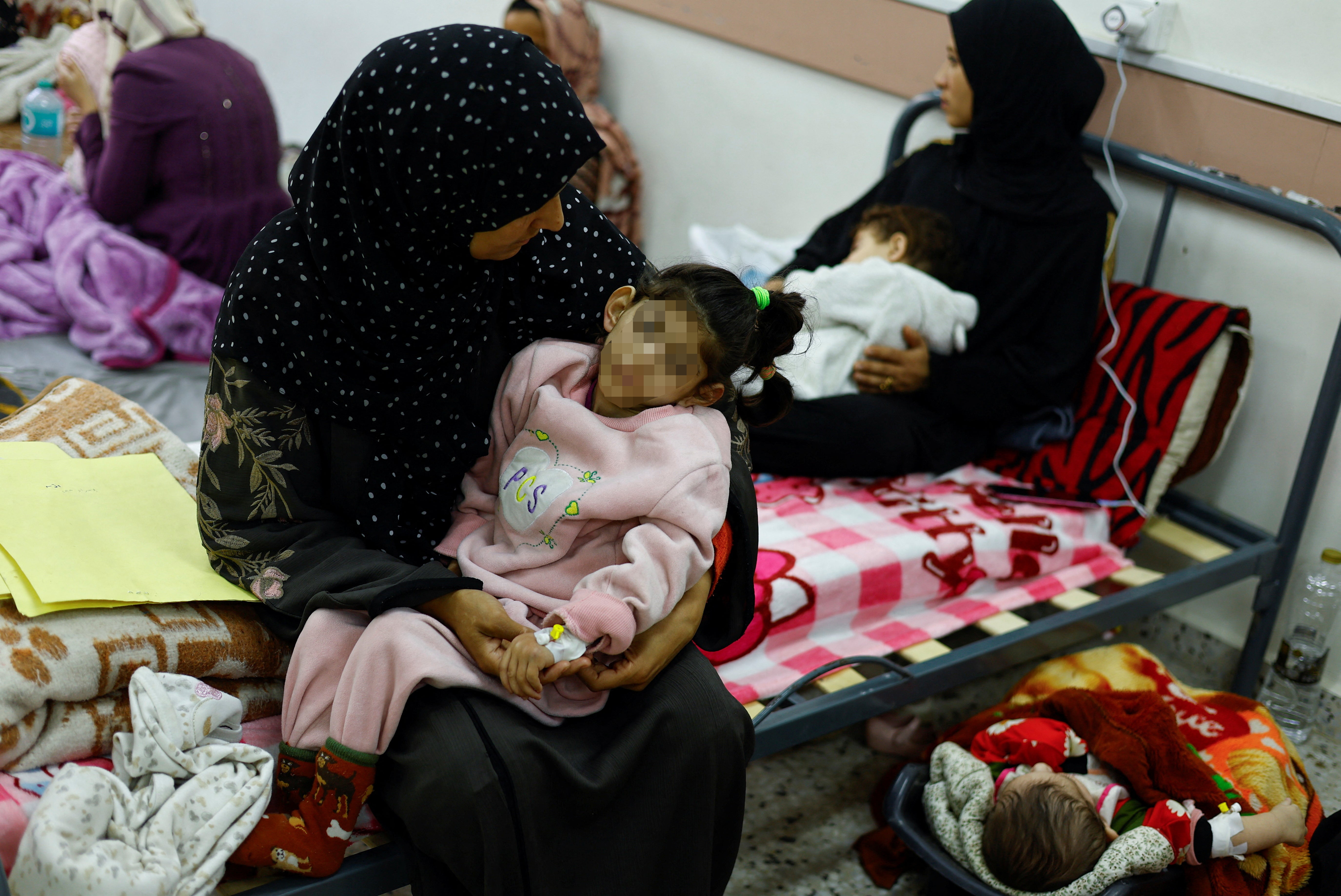 A Palestinian woman with her child in a Gaza hospital