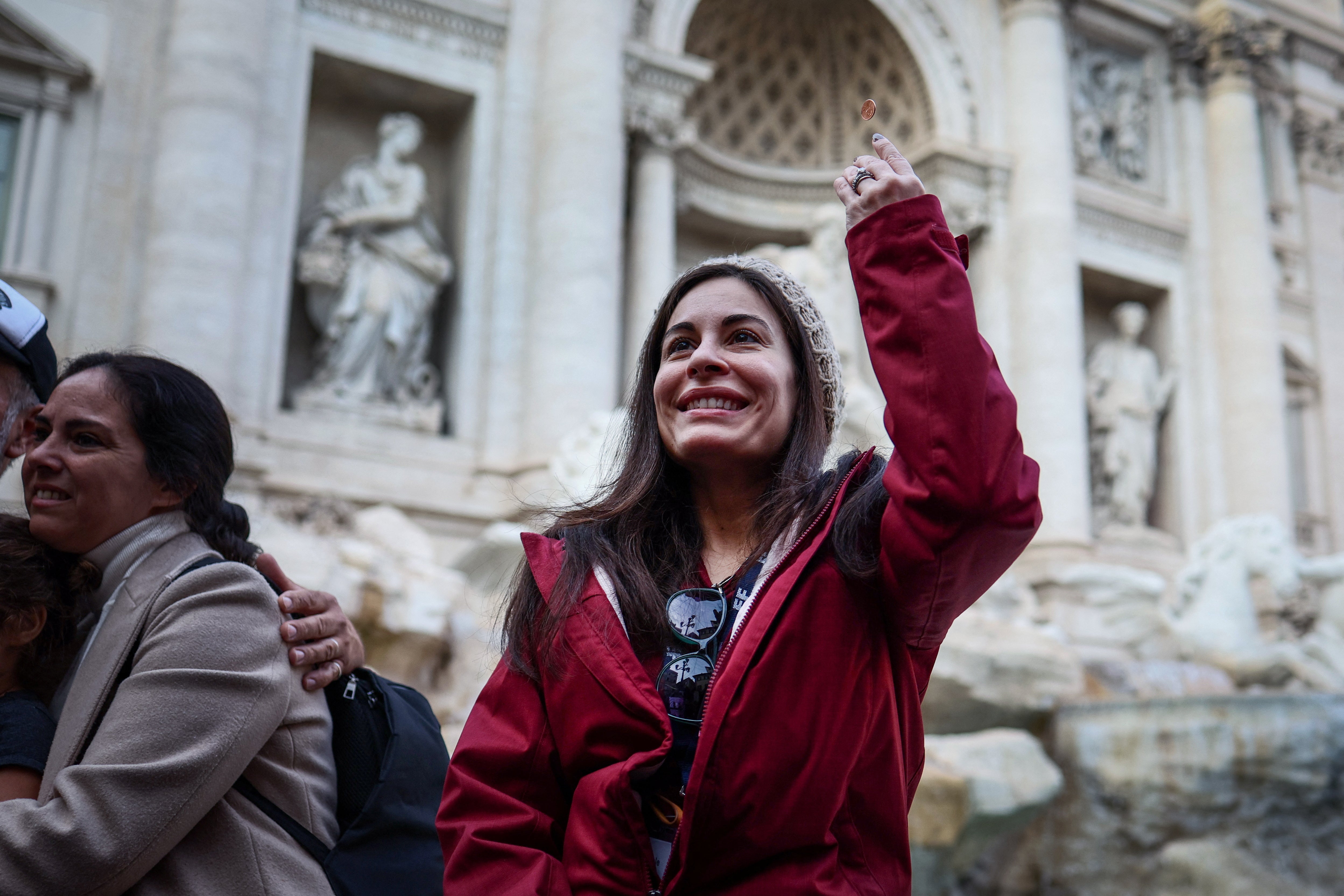 Yula Cole, from Brazil, throws a coin into the Trevi fountain