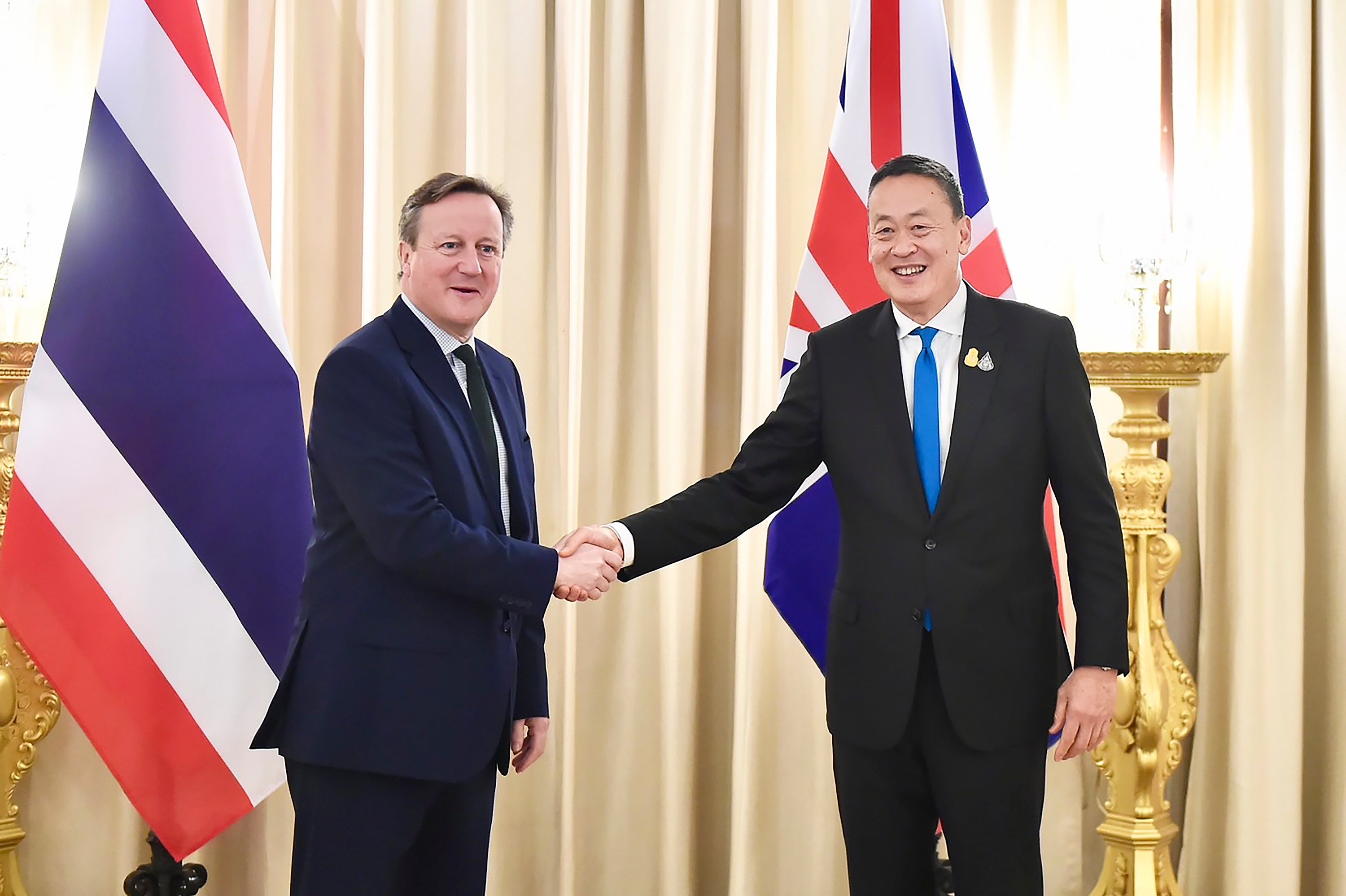 In this photo released by the Government Spokesman Office, Britain's Foreign Secretary, David Cameron, left, shakes hand with Thailand's Prime Minister Srettha Thavisin, at the Government house in Bangkok, Thailand, Wednesday, March 20, 2024