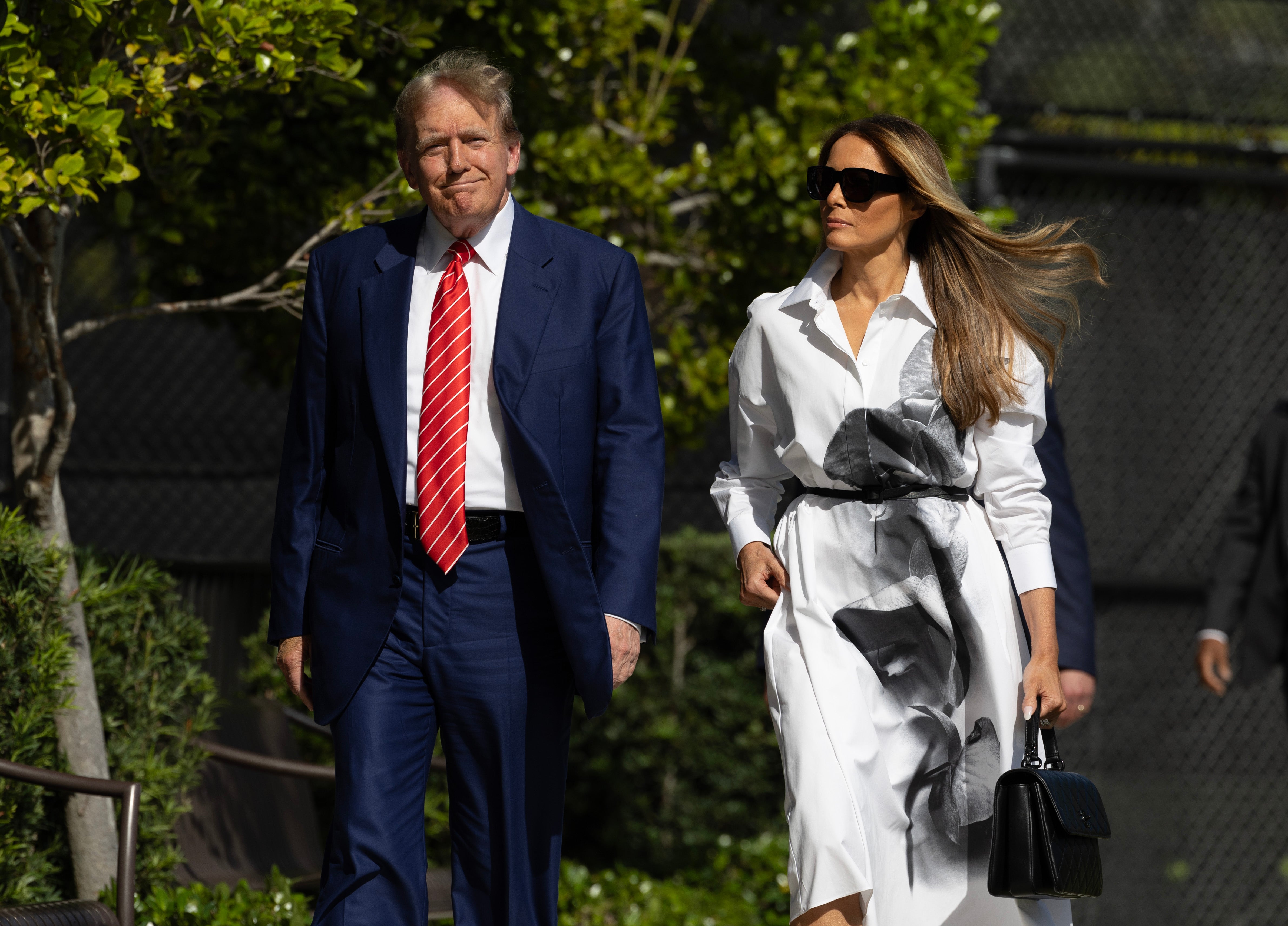 Former US President Donald Trump and former first lady Melania Trump walk together as they prepare to vote at a polling station in Florida