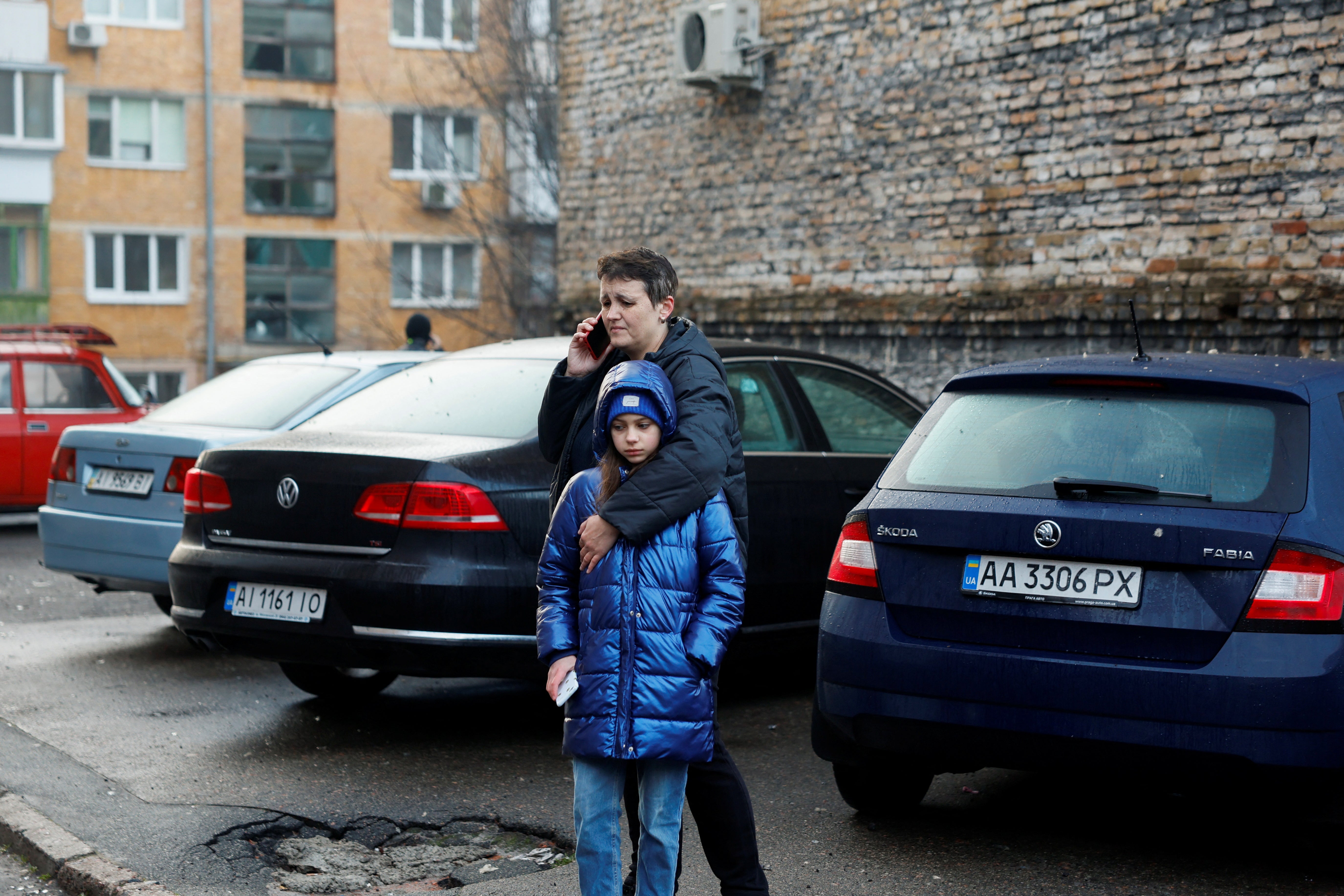 <p>People stand in front of vehicles following a Russian missile strike, amid Russia’s attack on Ukraine, in Kyiv, Ukraine 21 March 2024</p>