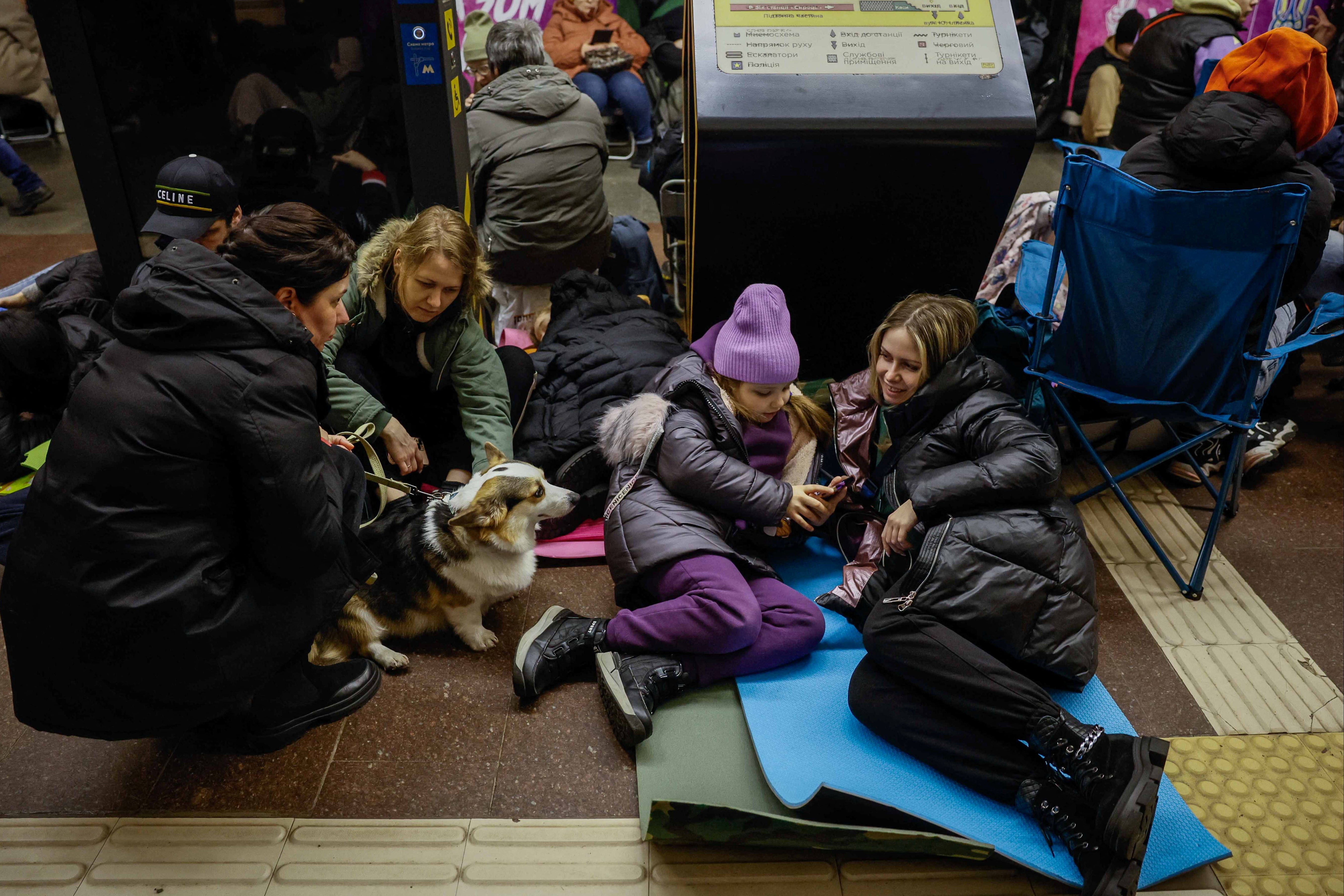 People take shelter inside a metro station in Kyiv on 21 March