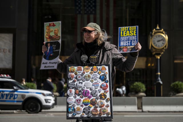 <p>A person sells “Anti-Trump” buttons in front of Trump Tower in New York City on 21 March 2024</p>