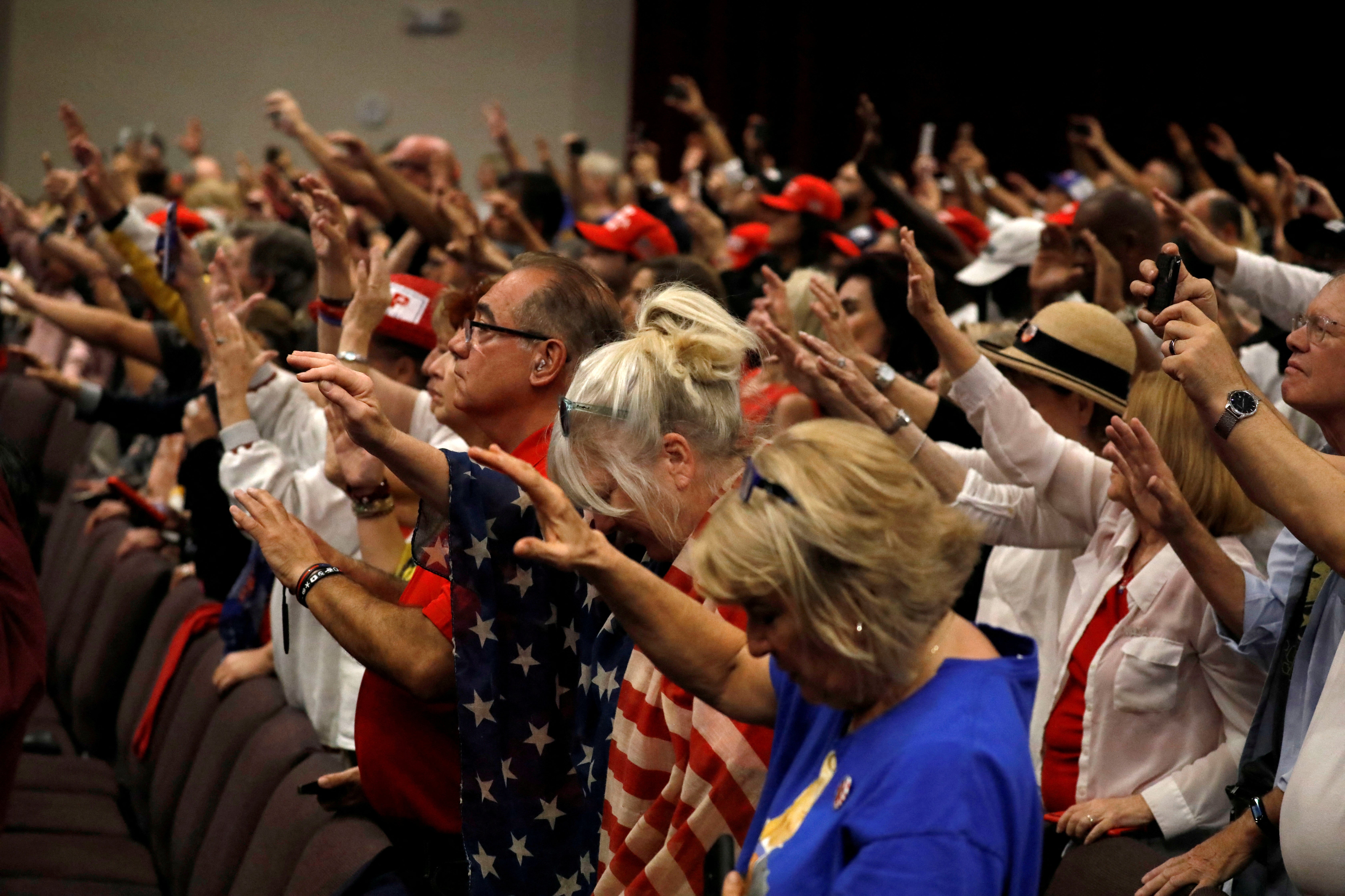 Supporters pray for US President Donald Trump before he make a speech to evangelical supports in Miami, Florida