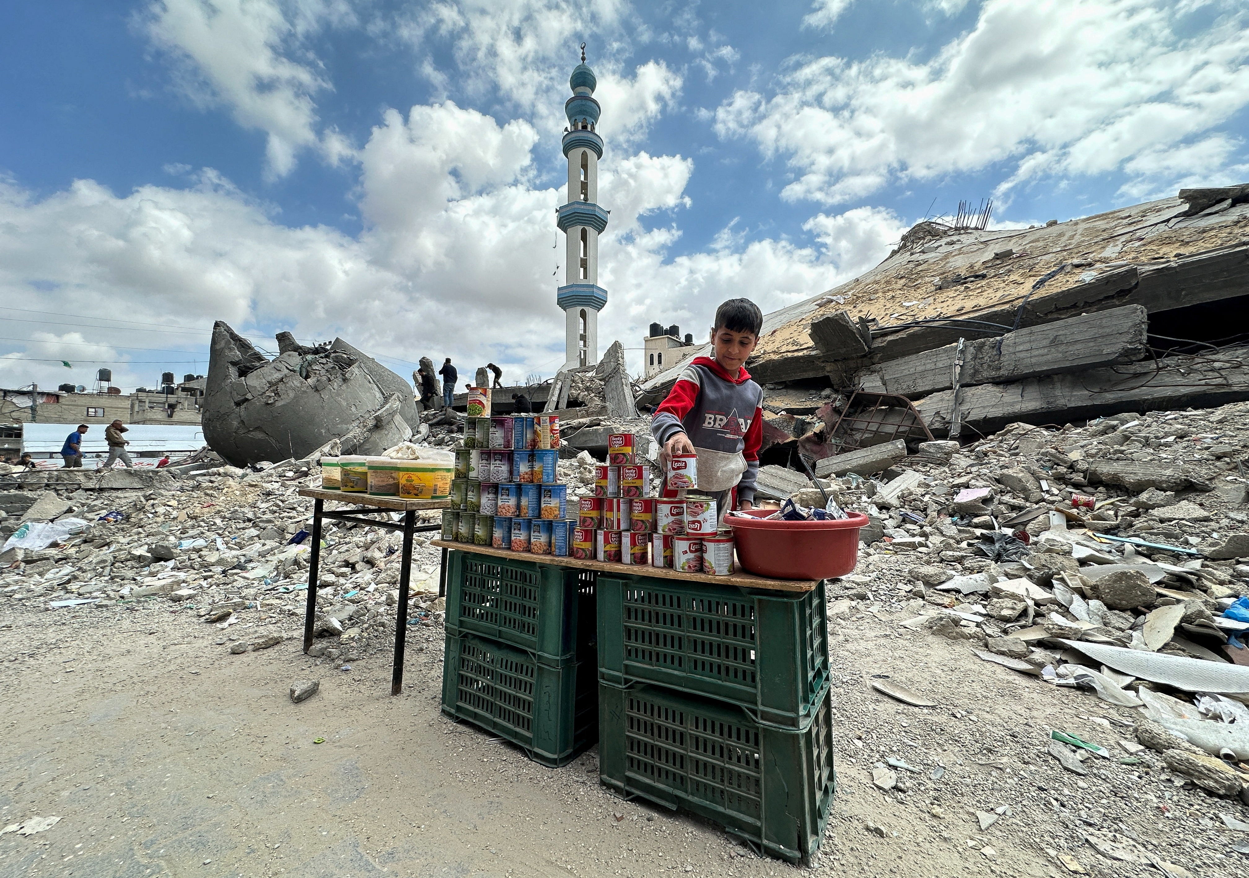 A boy stands next to canned food in Rafah in the south of Gaza on 22 March