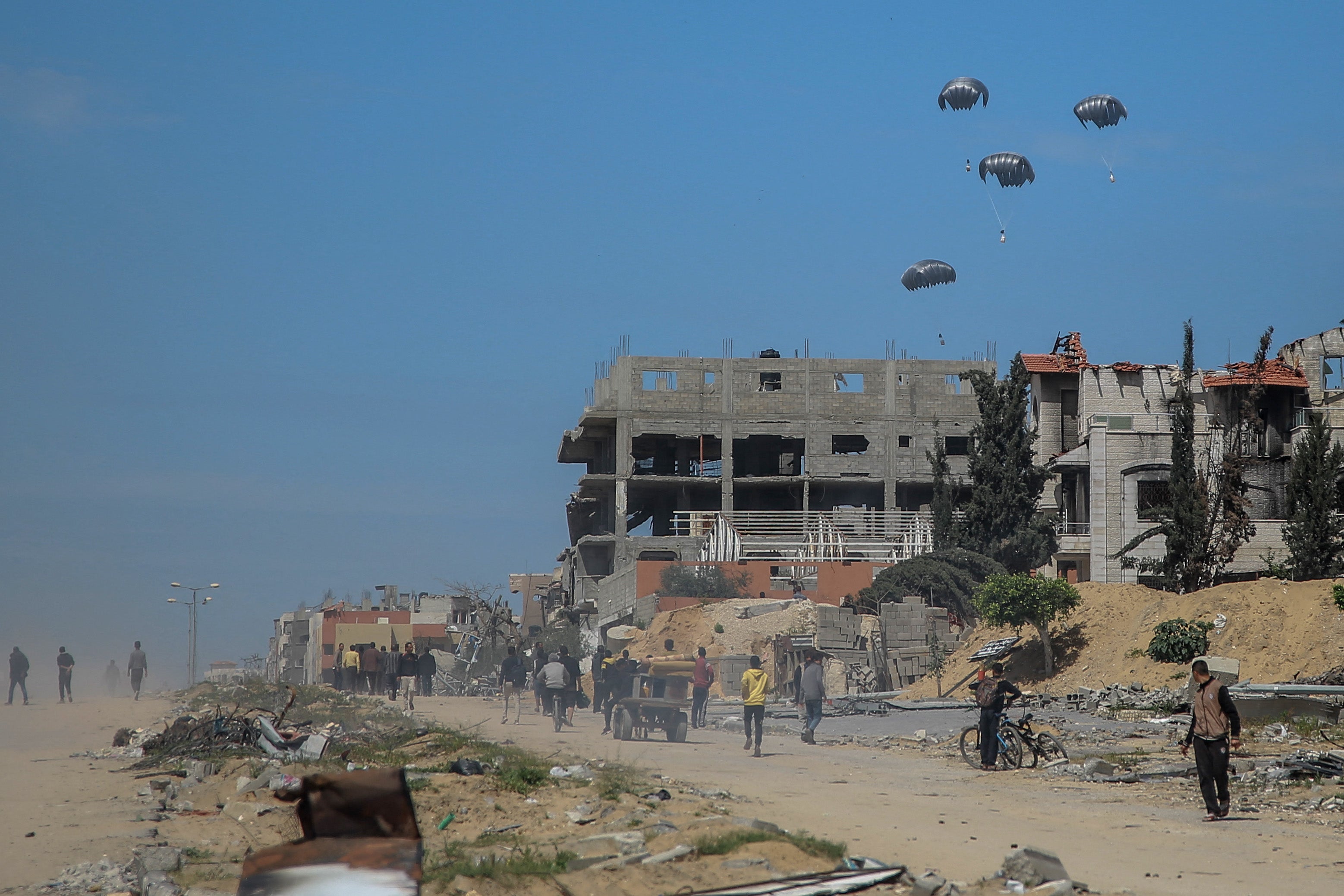 Humanitarian aid parcels attached to parachutes are airdropped from military aircraft over Gazaon 21 March