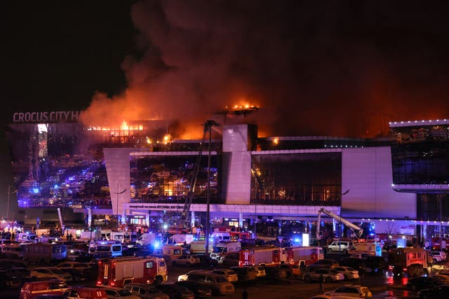 <p>Emergency services vehicles are seen outside the burning Crocus City Hall concert hall following the shooting incident in Krasnogorsk, outside Moscow, on March 22, 2024</p>