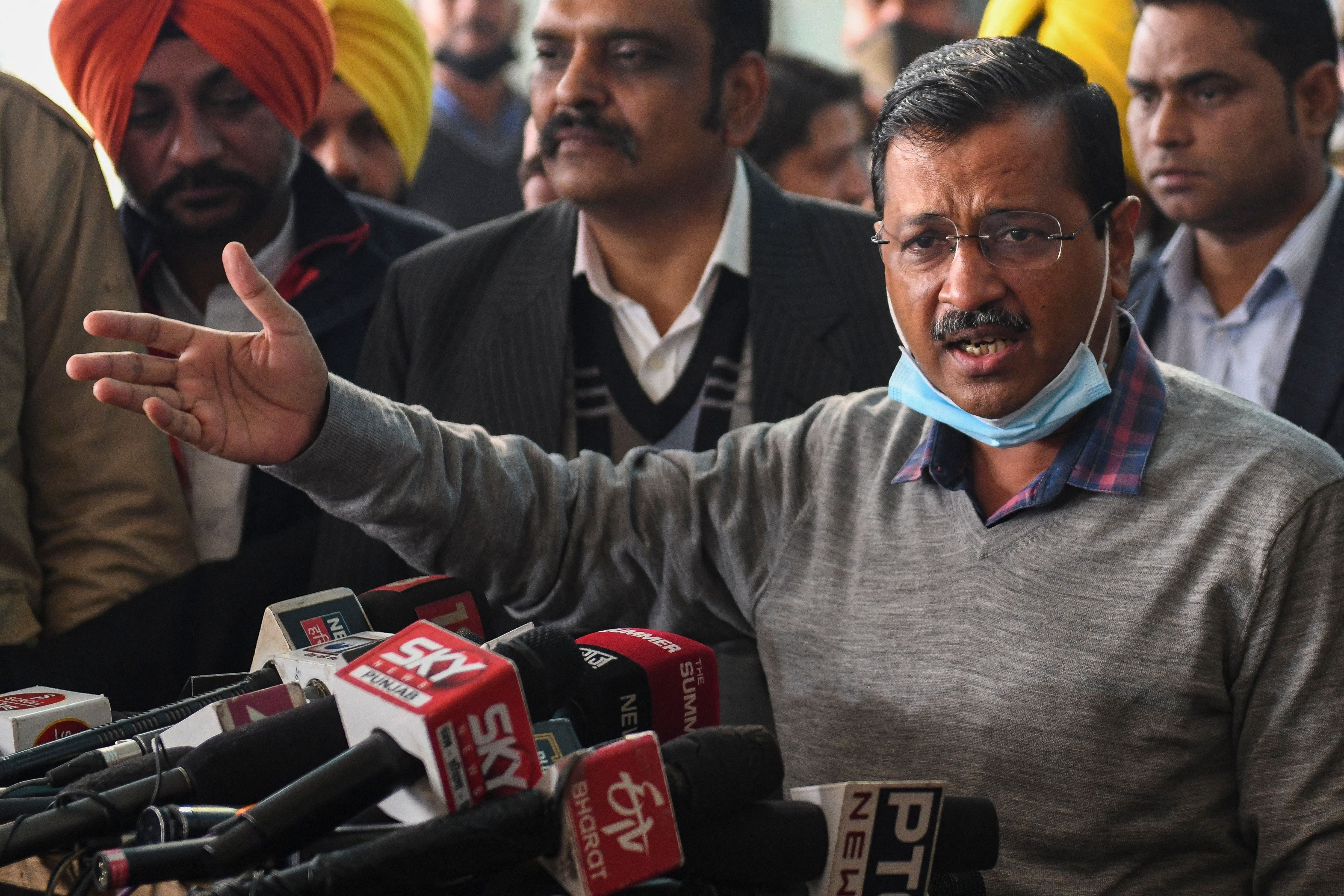 Leader of the Aam Aadmi Party (AAP) and Delhi's chief minister Arvind Kejriwal (C) speaks to the members of the media upon his arrival at Guru Ram Dass Jee International Airport on 24 December 2021