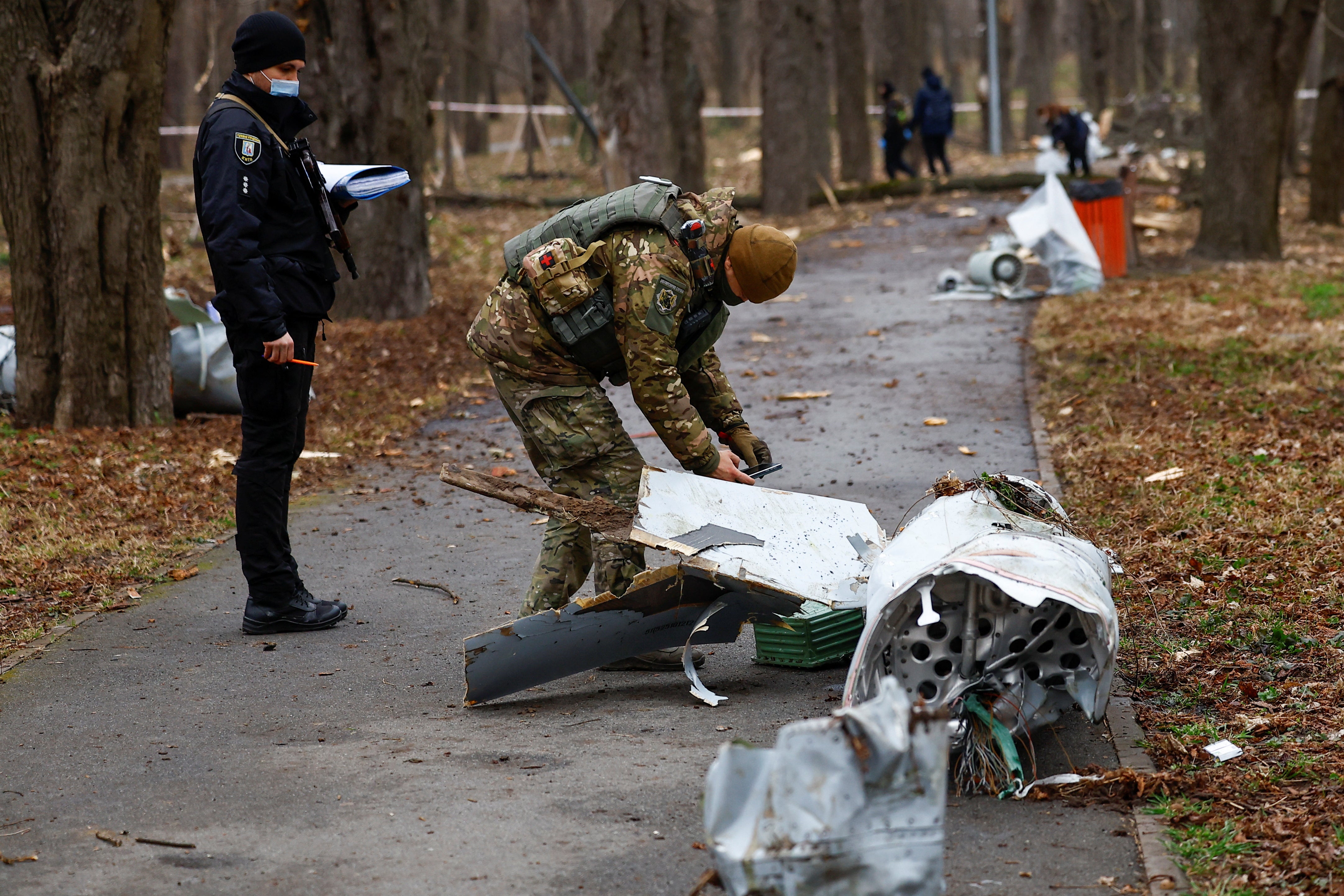 Police officers inspect a part of a Russian Kh-55 cruise missile, intercepted during a missile strike