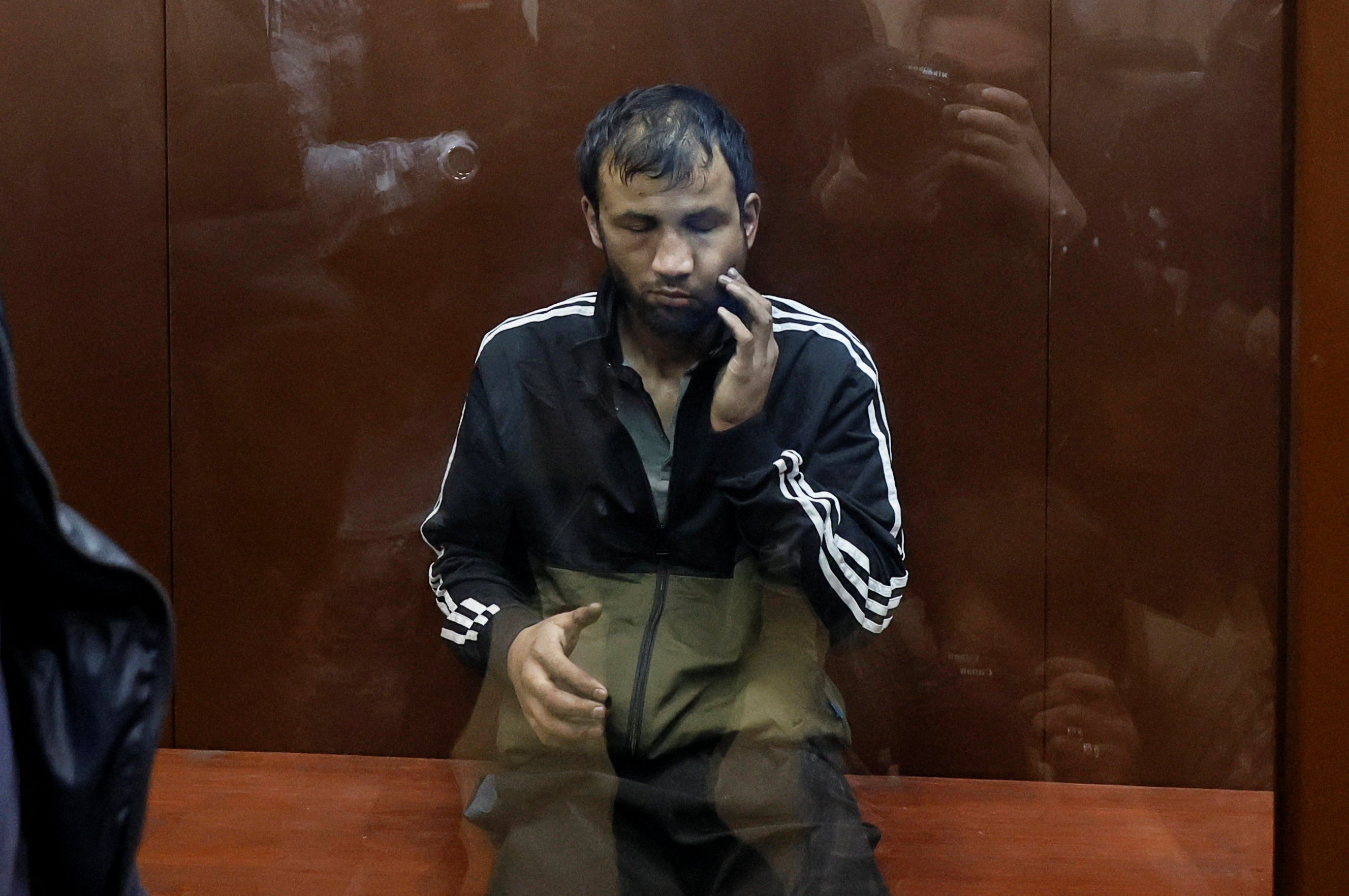 Shamsidin Fariduni, a suspect in the shooting attack at the Crocus City Hall concert venue, sits behind a glass wall in court