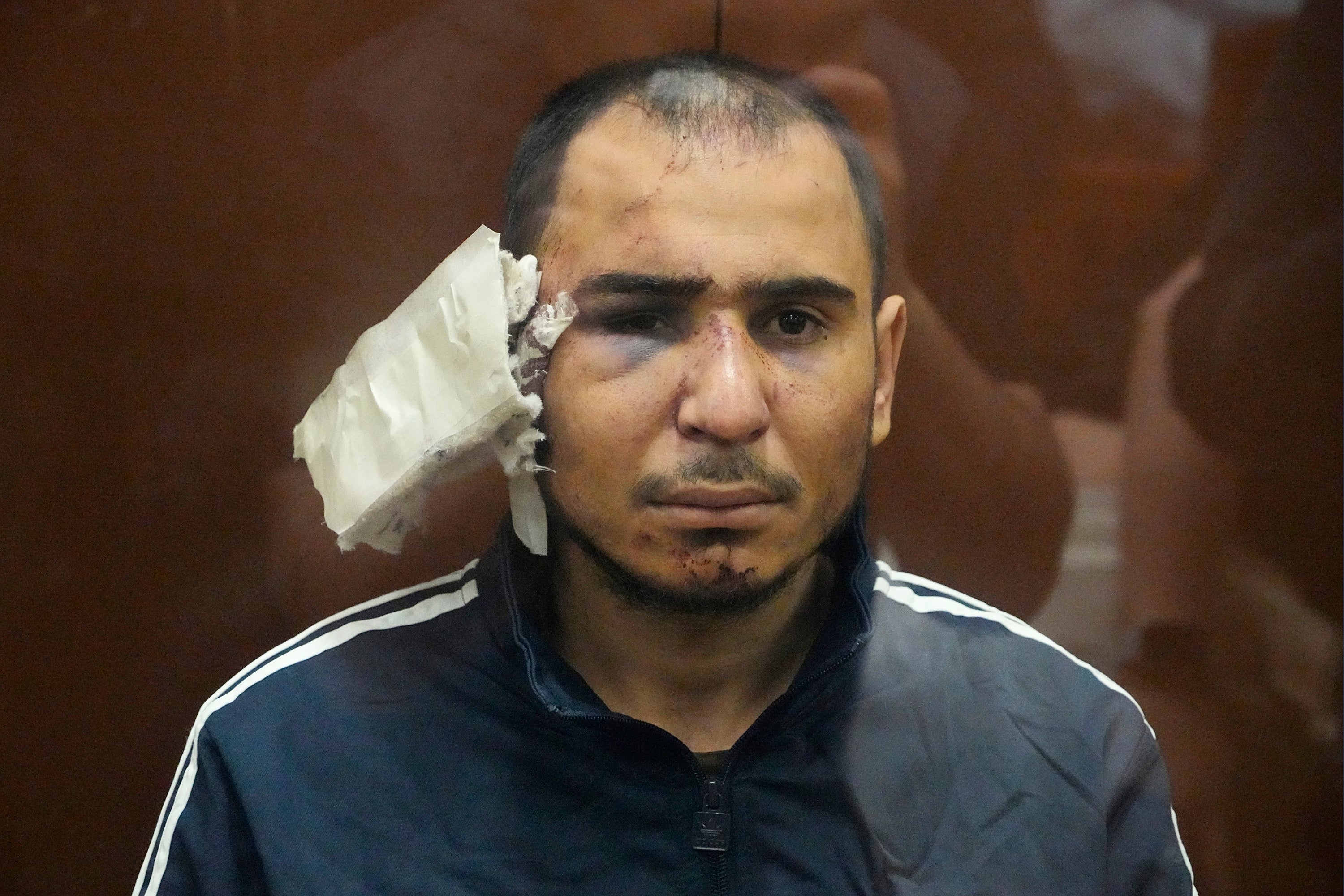 A man identified as Saidakrami Murodali Rachabalizoda, a suspect in the Crocus City Hall shooting on Friday, sits in a glass cage in the Basmanny District Court in Moscow