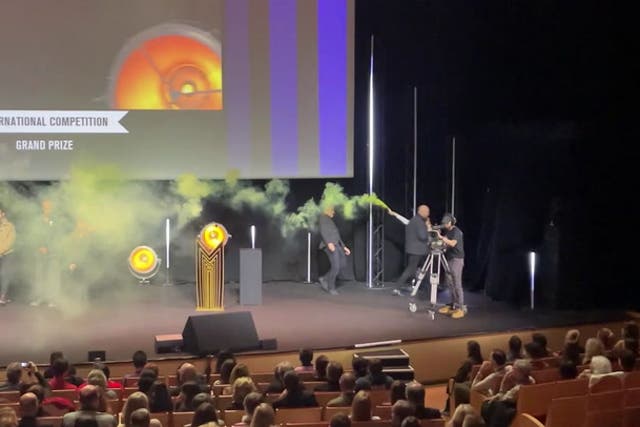 <p>Activist lights flare on stage during TV festival in France.</p>