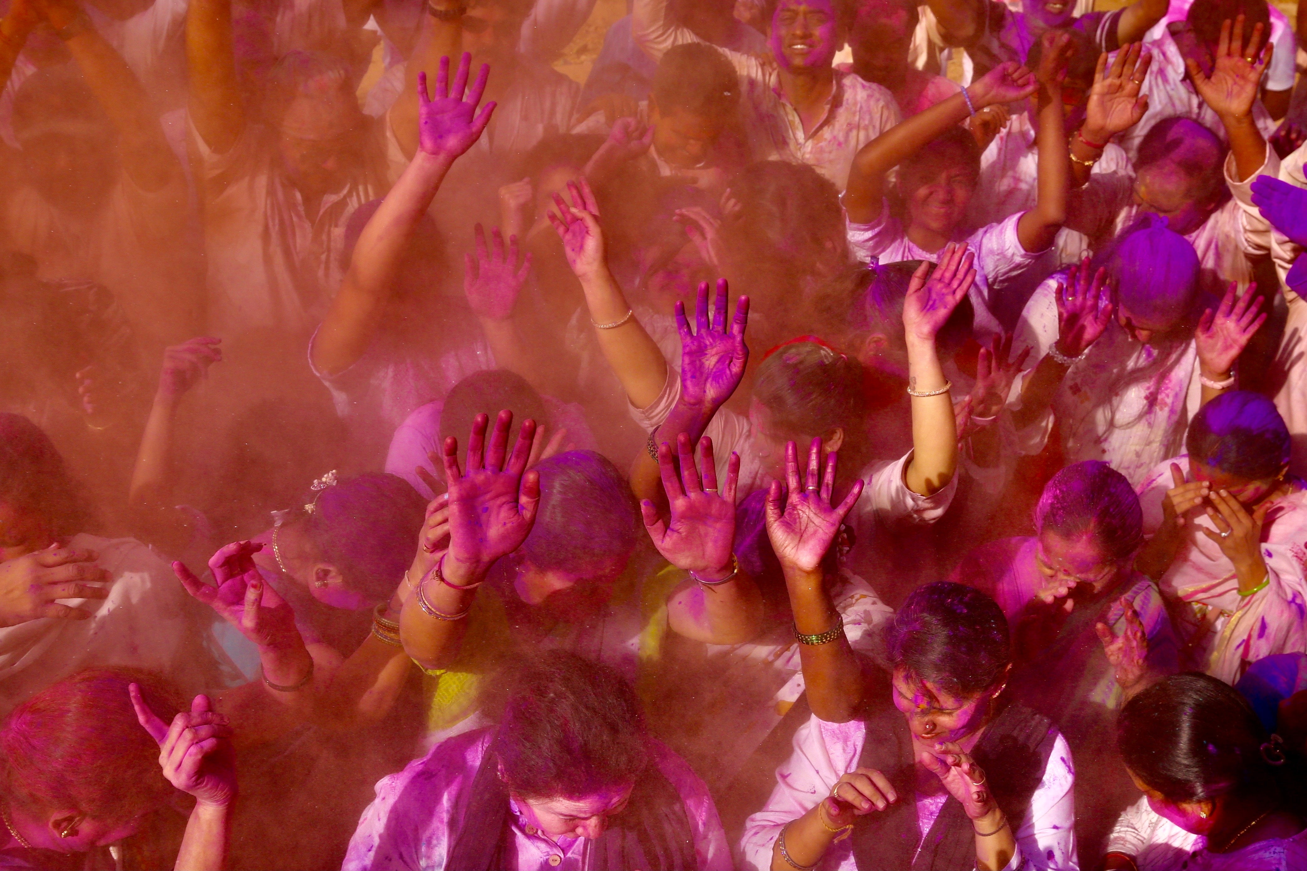 People covered with colored powder take part in the Holi festival celebrations in Bangalore