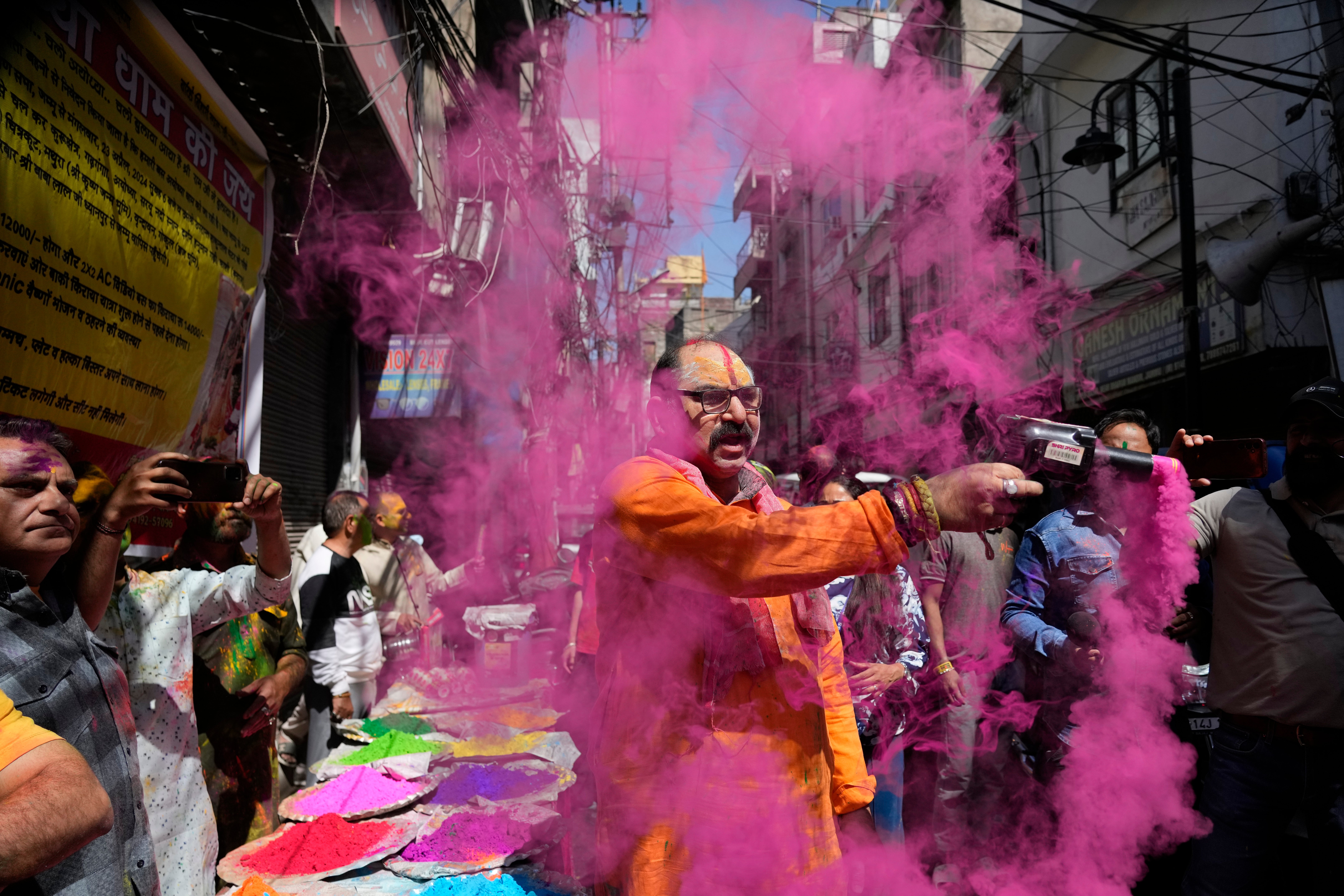 A Hindu man sprays coloured powder as people celebrate Holi, the Hindu festival of colors, in Jammu, India