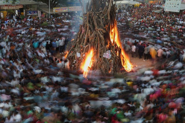 <p>File. Hindus walk around a bonfire during a ritual as part of the Holi festival celebrations in Ahmedabad, India </p>