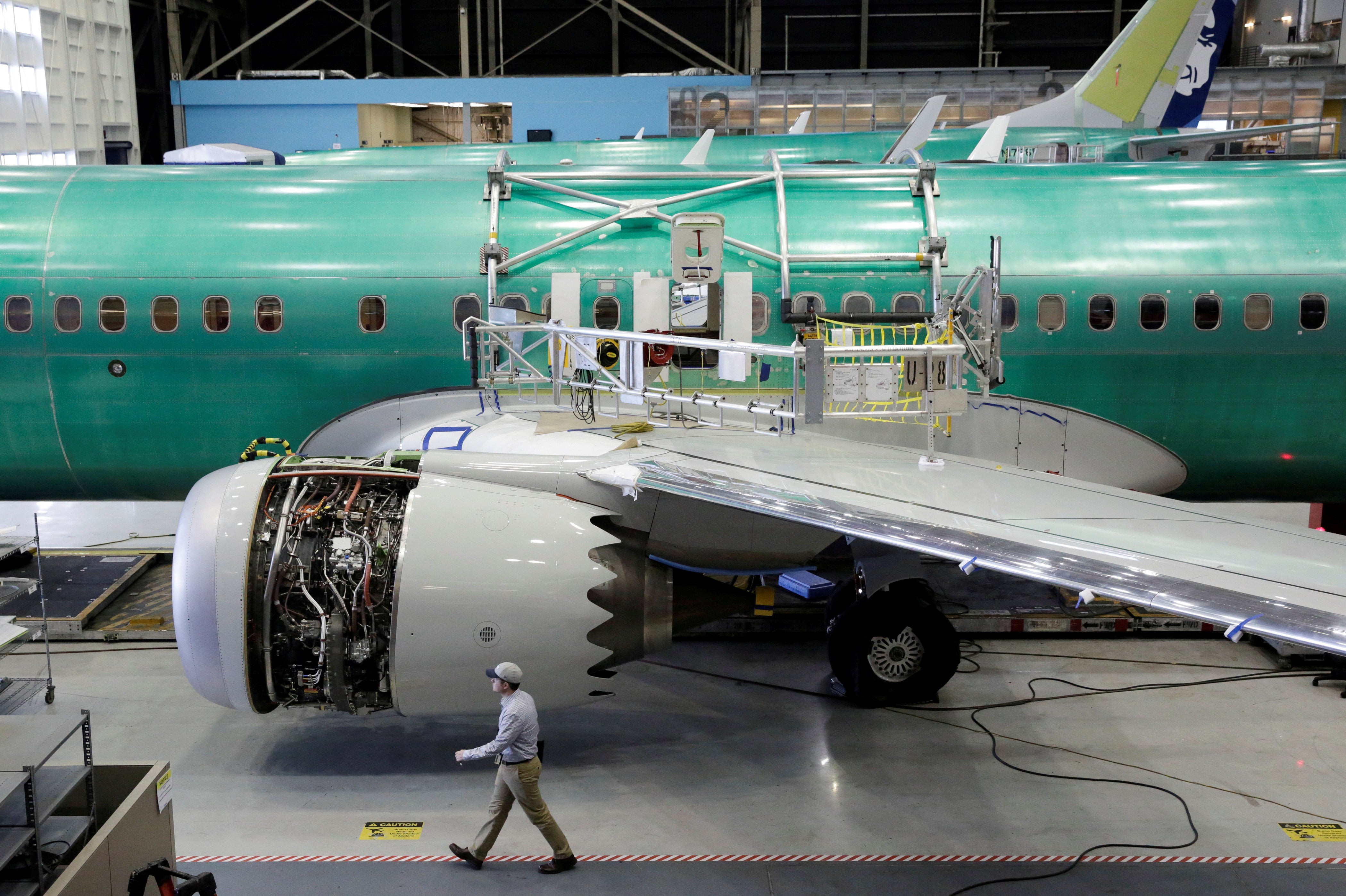 A worker walks past a Boeing 737-MAX under construction