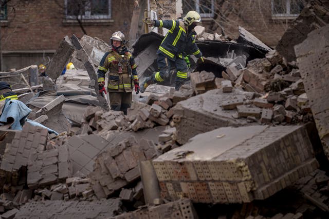 <p>Ukrainian first responders walk in the rubble of a building in the Pecherskyi district, after a Russian air attack in Kyiv, Ukraine</p>
