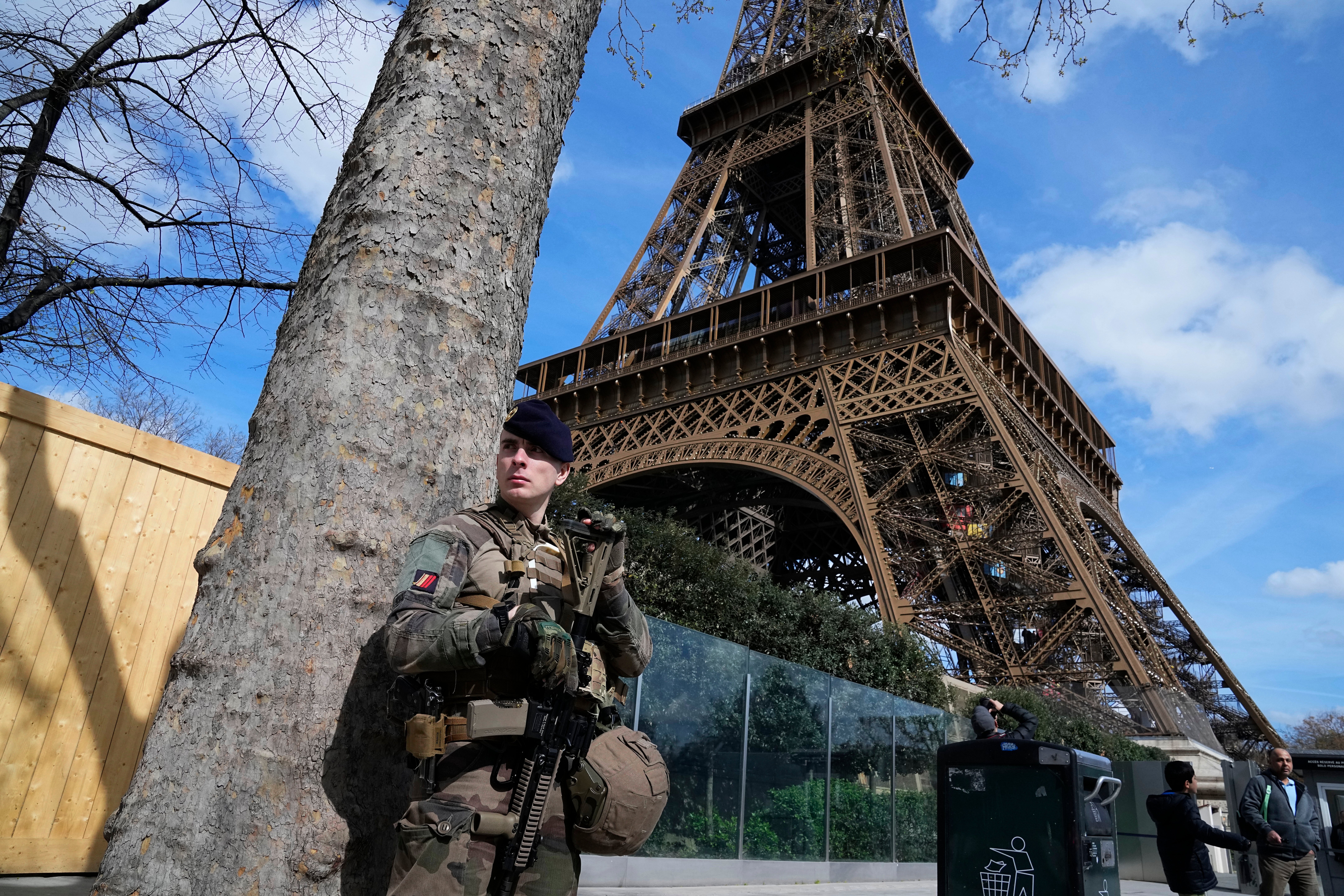 A soldier patrols close to the Eiffel Tower on Monday as France stepped up its terror threat level