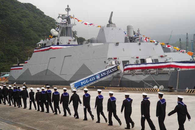 <p>Navy soldiers walk past Taiwan-made corvette warship during inauguration ceremony in Yilan on 26 March</p>