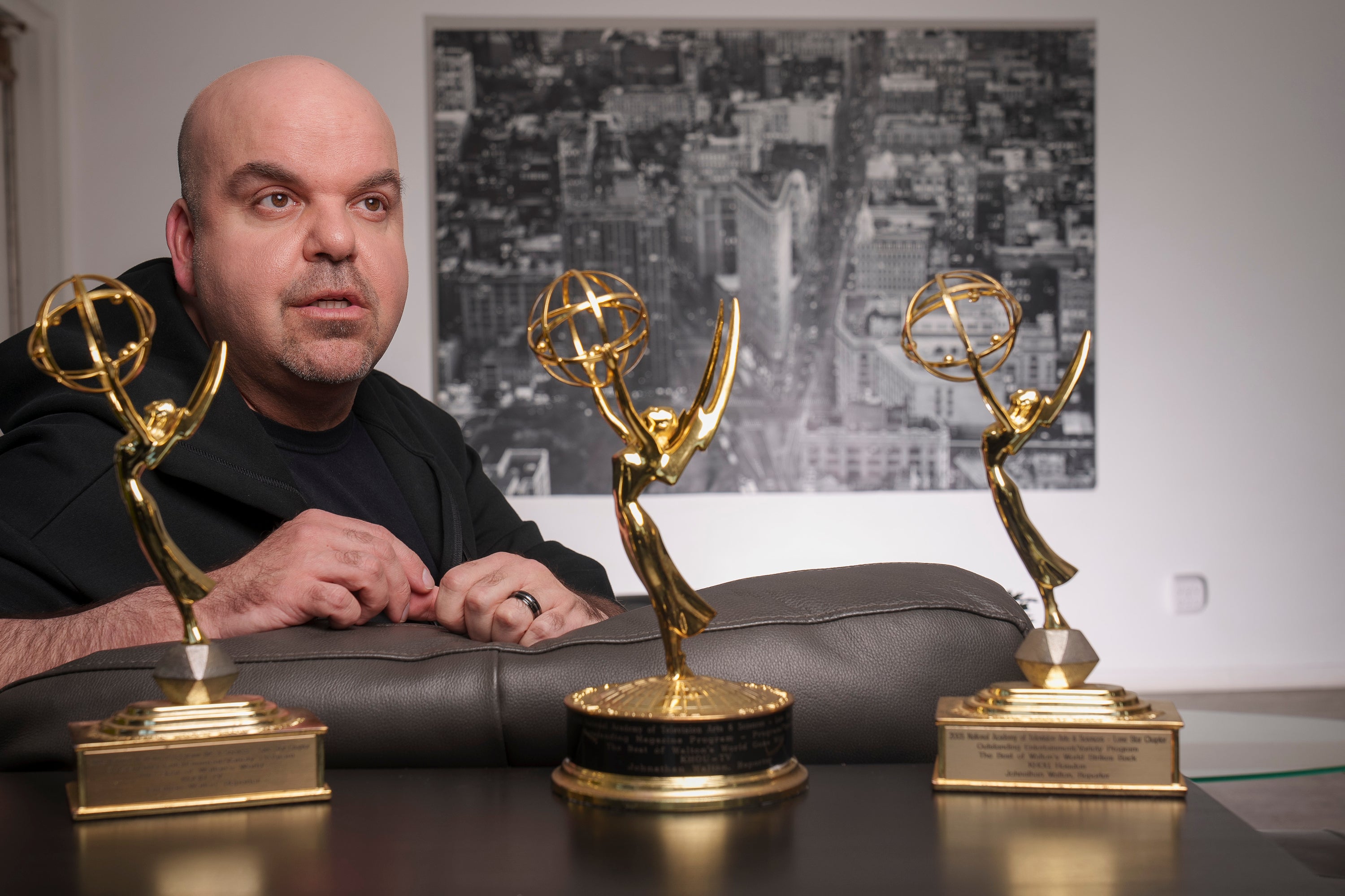 Emmy Award-winning producer Johnathan Walton poses for a photo with his Emmy Awards at his apartment