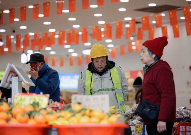<p>People stand in a grocery store in Shanghai, China</p>