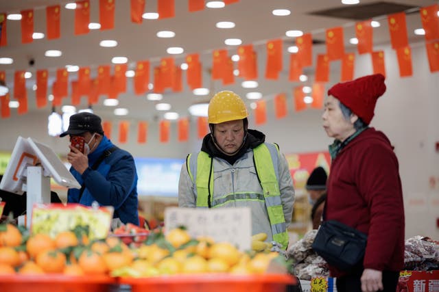 <p>People stand in a grocery store in Shanghai, China</p>