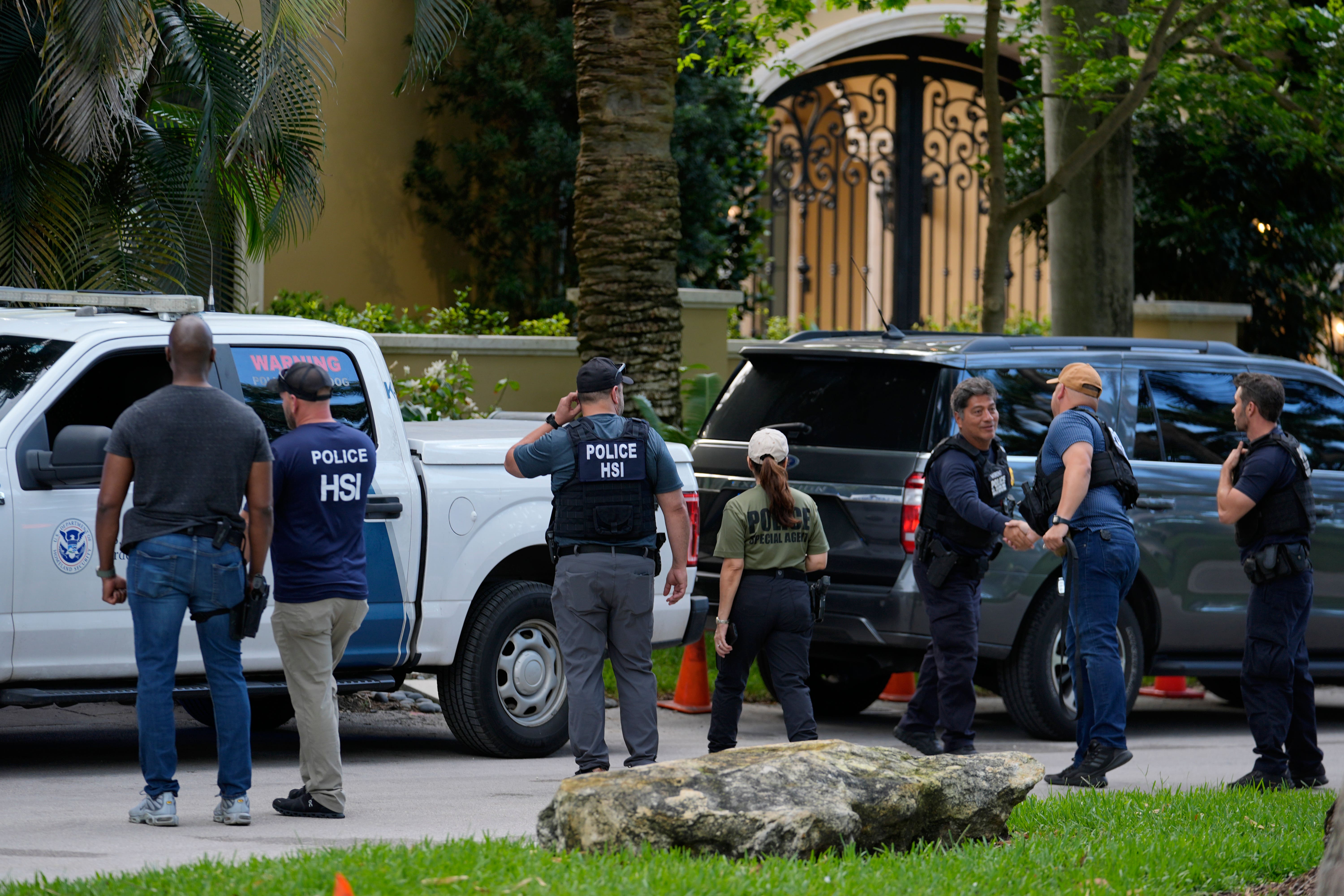 Law enforcement agents stand at the entrance to a property belonging to rapper Sean ‘Diddy’ Combs