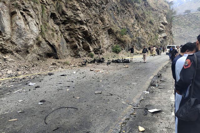 <p>Police officers examine the site of suicide bombing at a highway in Shangla, a district in the Pakistan’s Khyber Pakhtunkhwa </p>